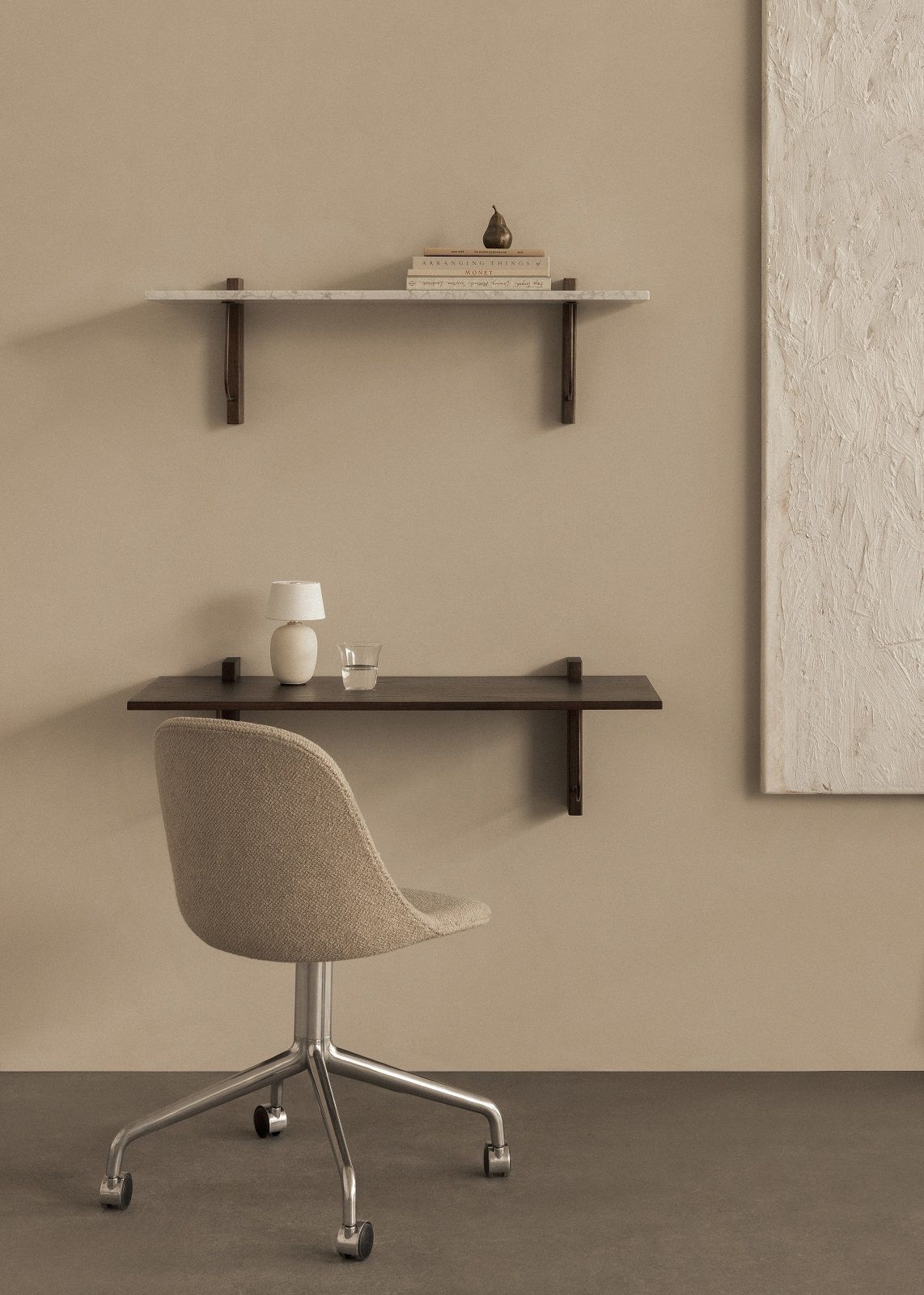 Corbel Wandschreibtisch von Audo Copenhagen mit Stuhl, Lampe und Dekoration an beiger Wand.