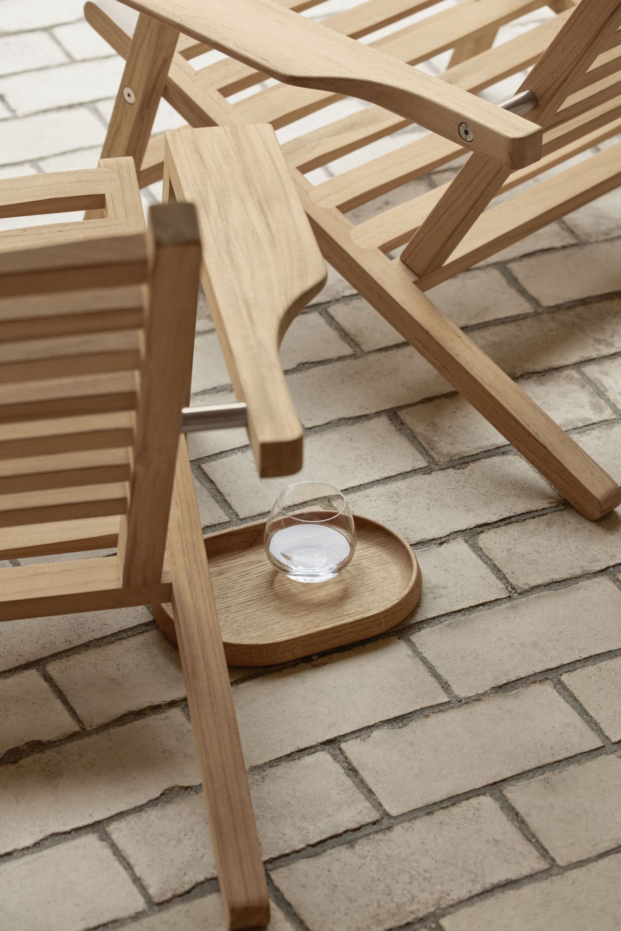 Detailaufnahme eines AH603 Sonnenstuhl Teak von Carl Hansen & Søn mit Getränk auf Ablage.