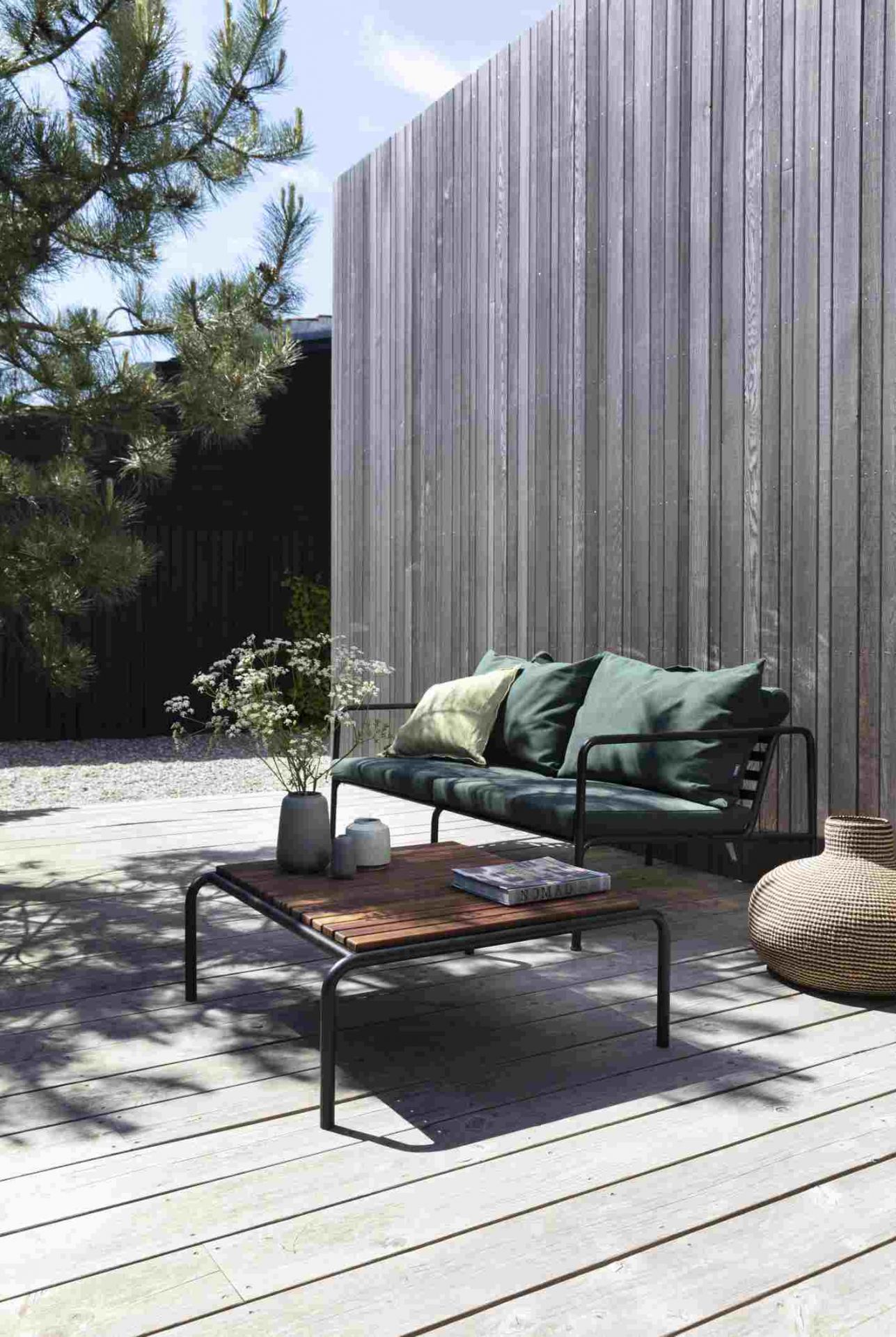 Avon 2-Sitzer Outdoor Sofa von Houe mit grünen Kissen und Holztisch auf einer Terrasse.