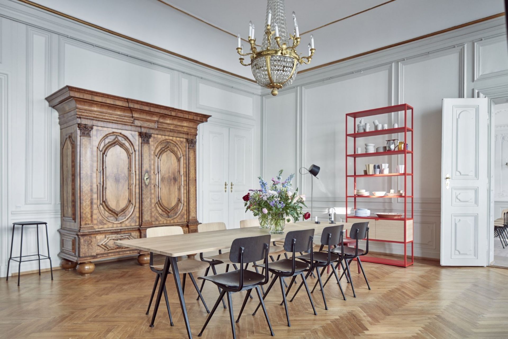 Innenaufnahme eines Esszimmers mit langem Holztisch und schwarzen Result Chair Stühlen von Hay.