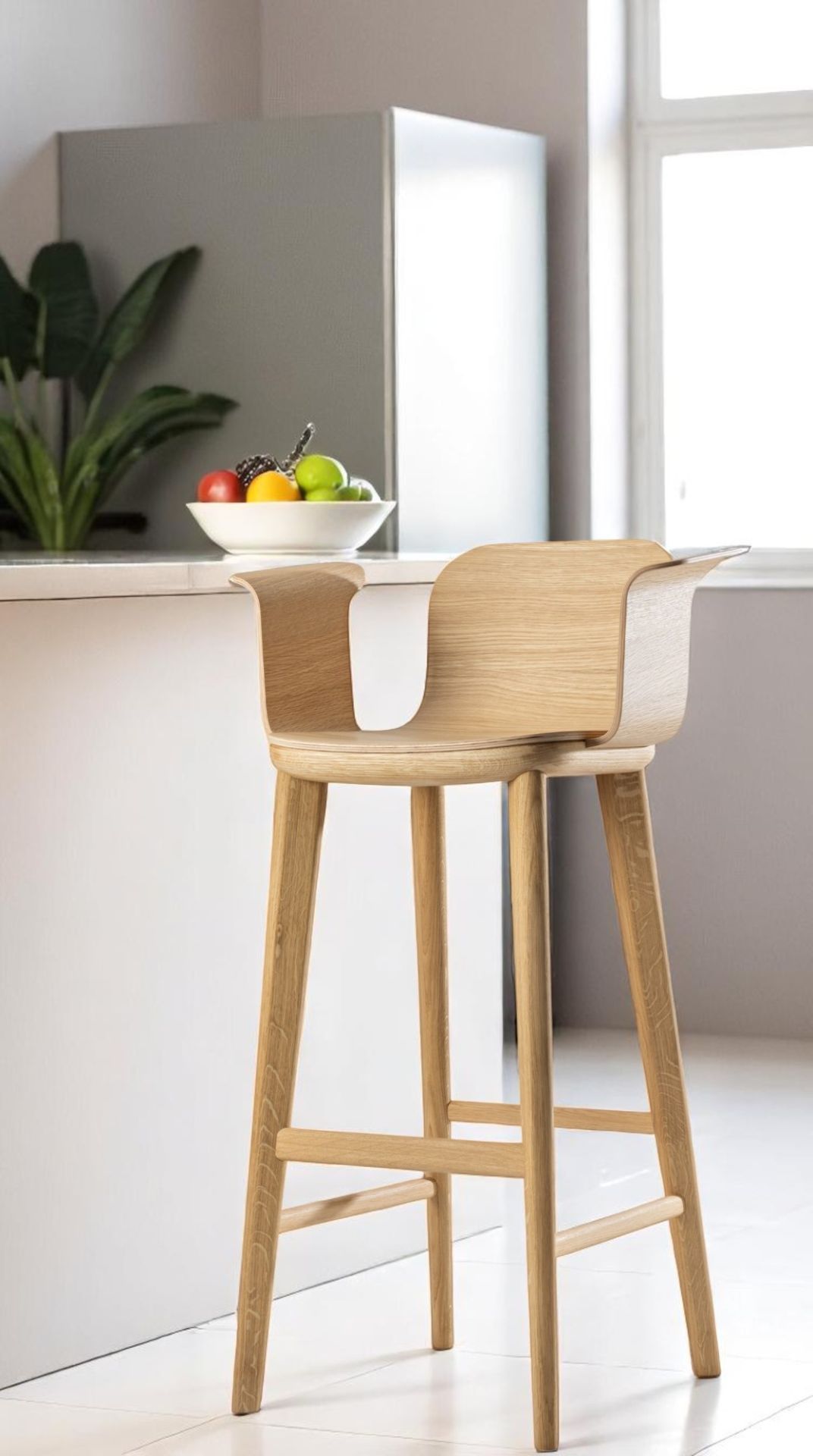 Aeon Comfort Barstool Barhocker mit Armlehnen aus hellem Holz, modernes Küchendesign mit Obstschale.