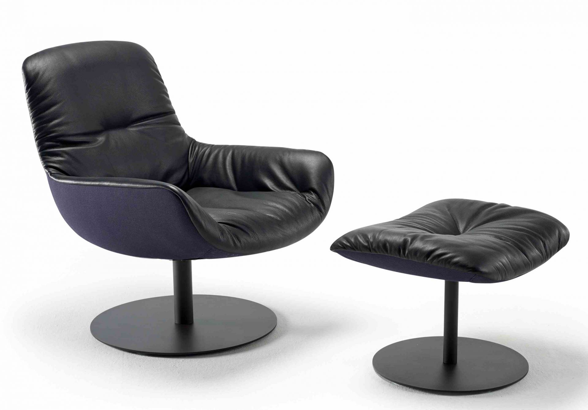 Leya Lounge Chair von Freifrau Manufaktur, schwarzer Ledersessel mit Fußhocker auf schwarzem Tellerfuß.