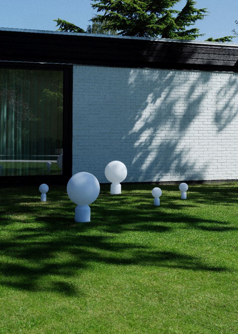 Mehrere Yo Lamp Akkuleuchten von Normann Copenhagen in verschiedenen Größen auf einer grünen Rasenfläche.