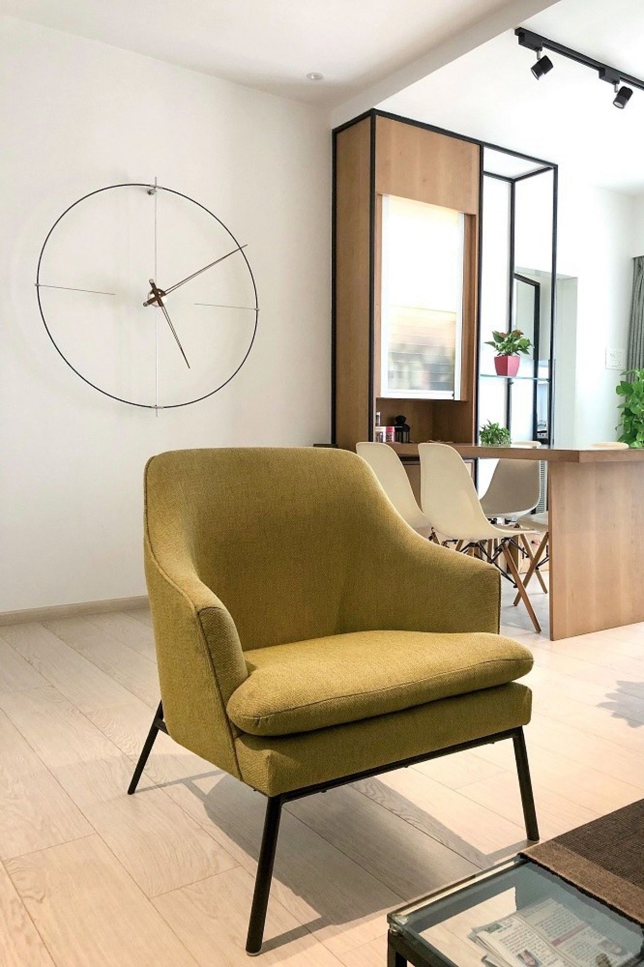 Moderne Bilbao Wanduhr von Nomon in Weiß und Schwarz im minimalistischen Wohnzimmer.