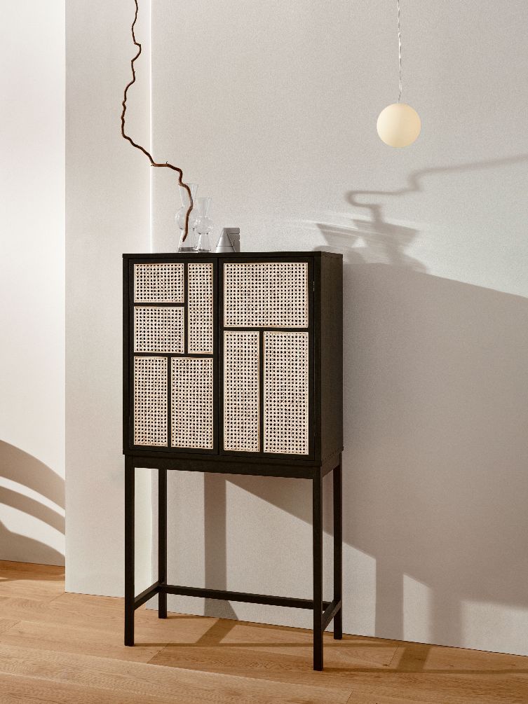 Luna Lamp Pendelleuchte von Design House Stockholm über einem schwarzen Schrank mit Rattangeflecht.