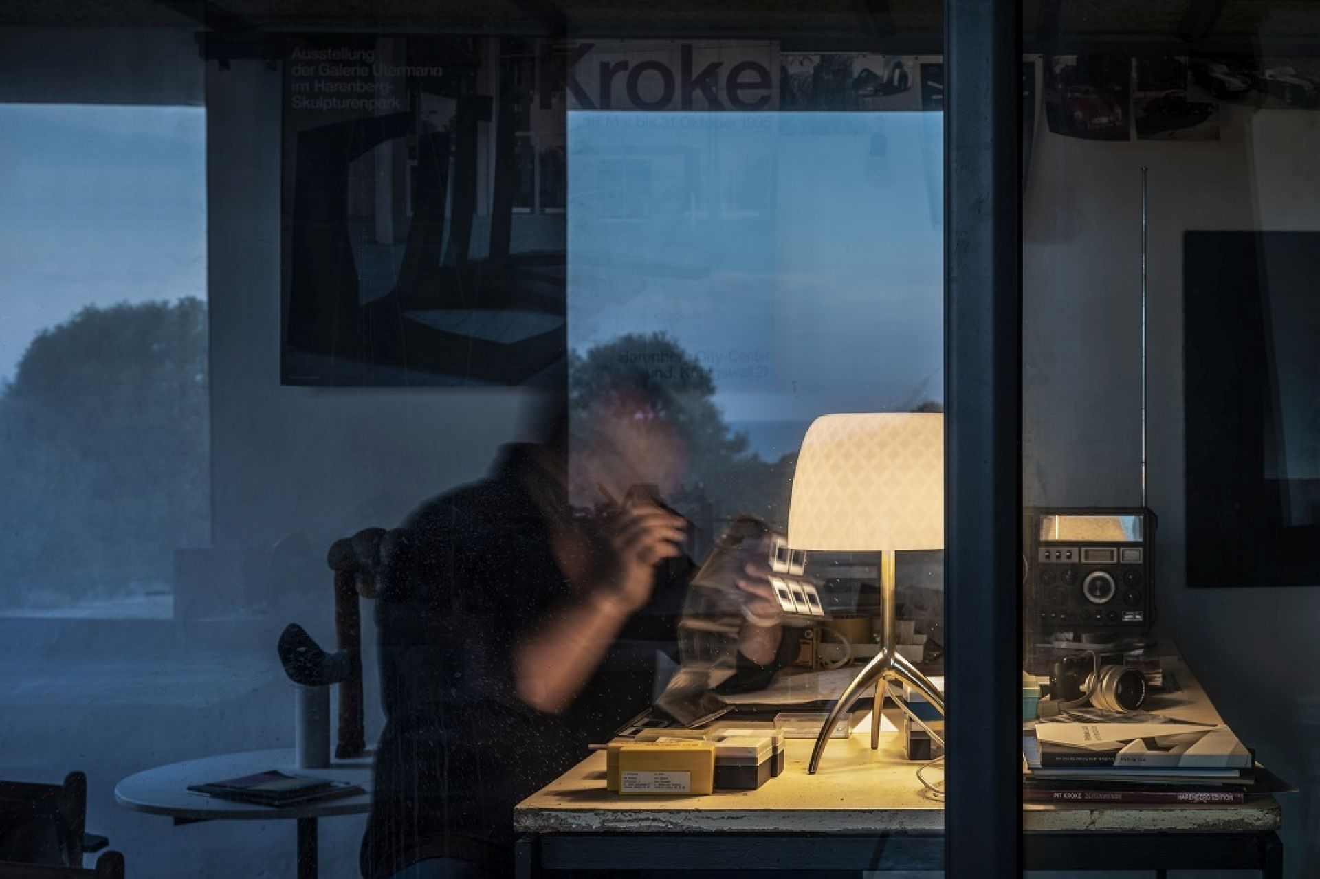Nahaufnahme der Lumiere Tischleuchte von Foscarini auf einem Schreibtisch mit Vintage-Radio und Büchern.