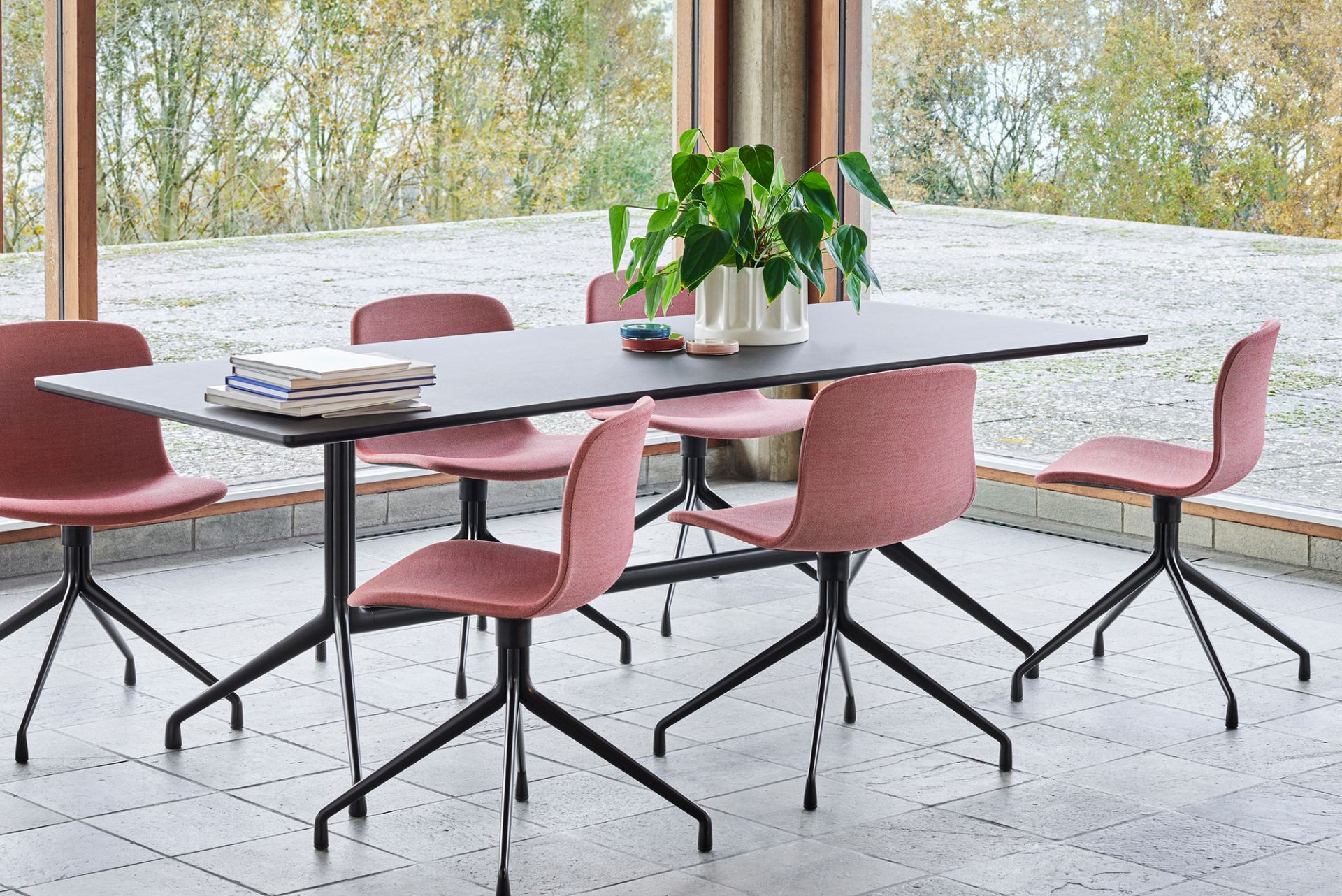 Esstisch mit sechs About a Chair AAC 11 Stühlen mit roter Vollpolsterung und schwarzem Vierfußgestell.