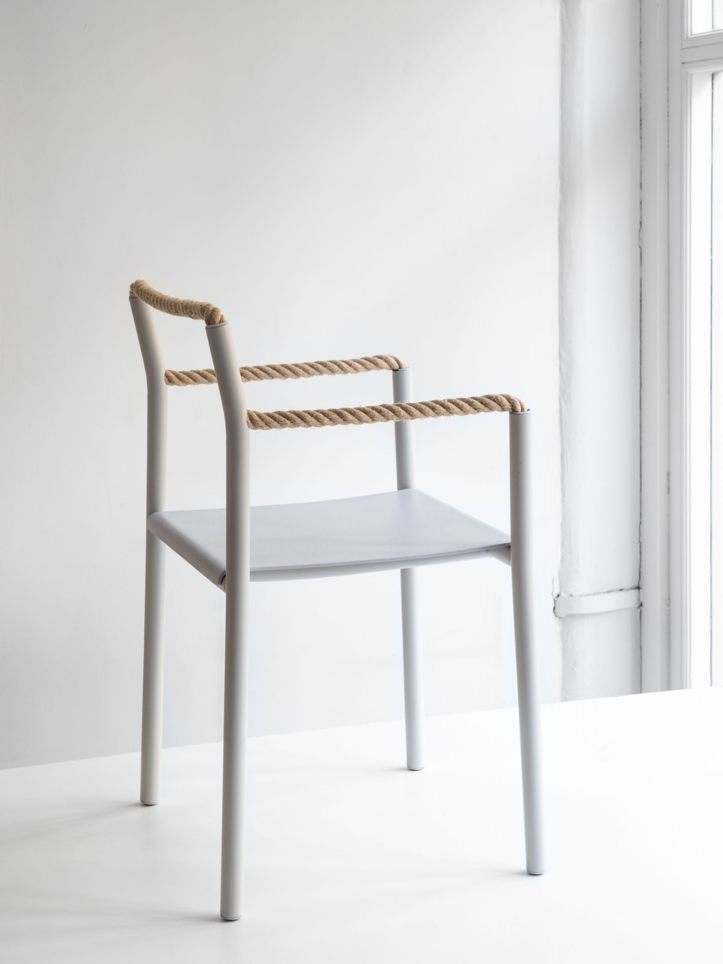 Artek Rope Chair Stuhl mit hellgrauem Rahmen und Seil-Detail an Armlehne und Rückenlehne.