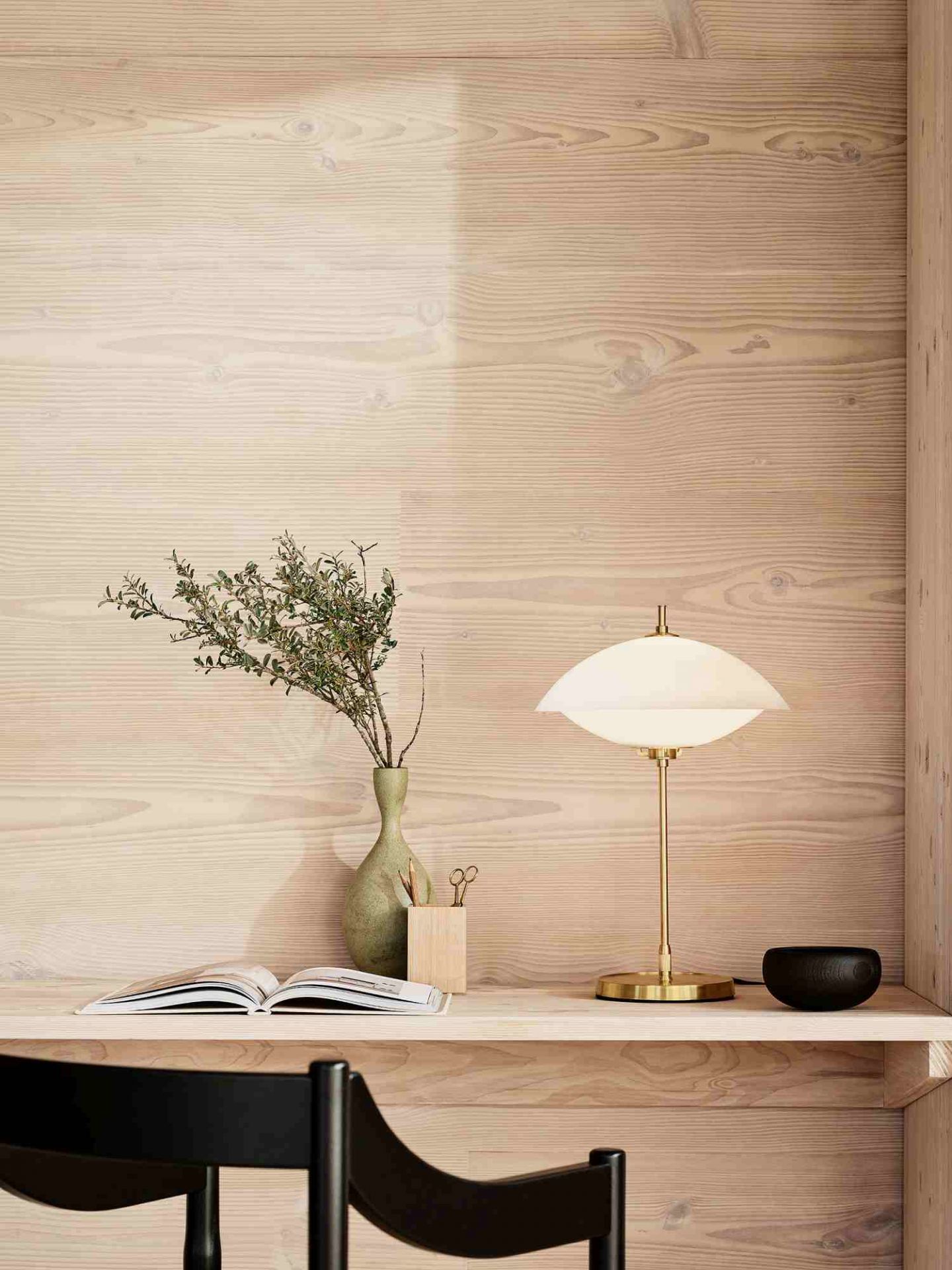 Nahaufnahme der Fritz Hansen Clam Tischleuchte mit Messingfuß und sanftem Licht.