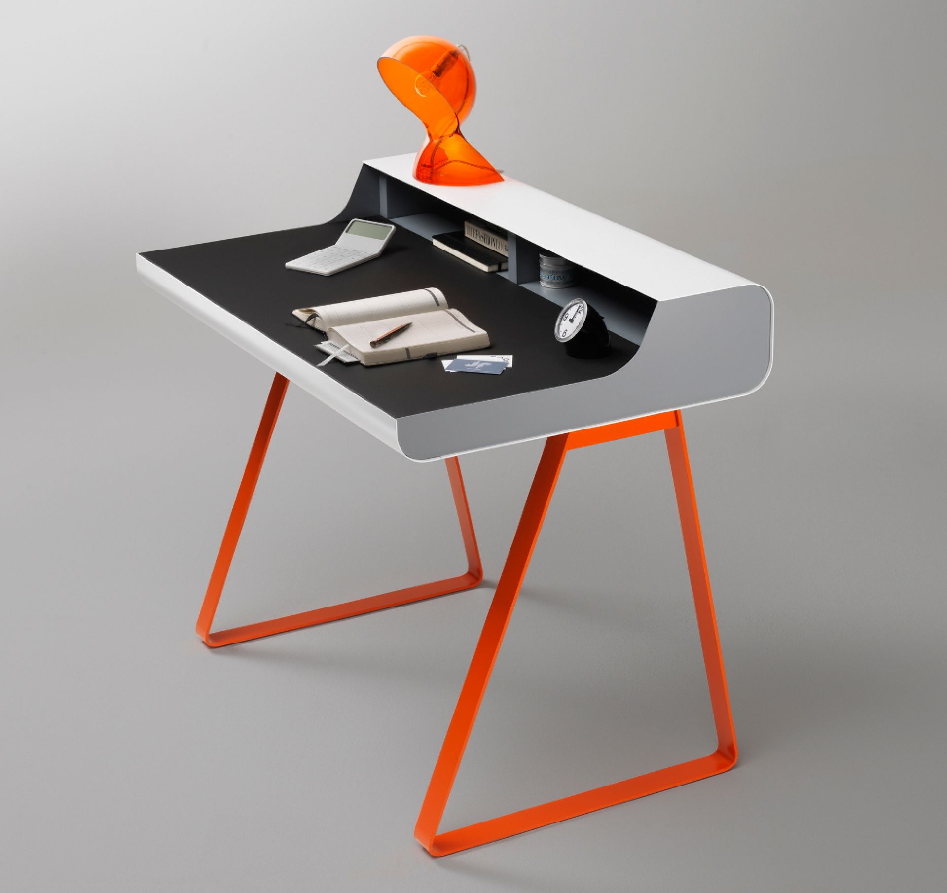 PS10 Schreibtisch von Müller Möbelfabrikation mit orangefarbenem Gestell, schwarzer Arbeitsfläche und weißen Ablagefächern.