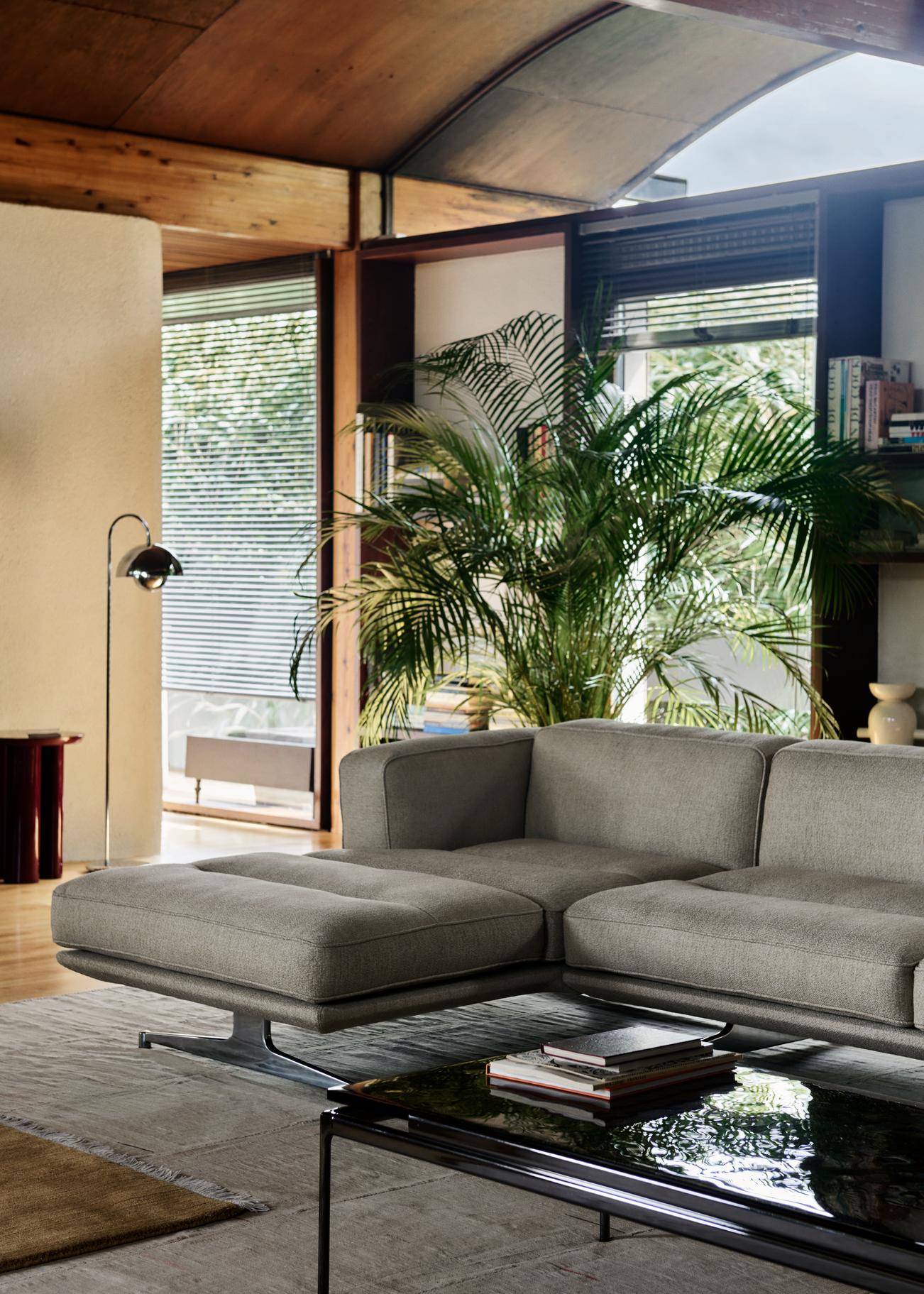 Flowerpot VP12 Stehleuchte von AndTradition neben einem grauen Sofa in einem hellen Wohnzimmer.
