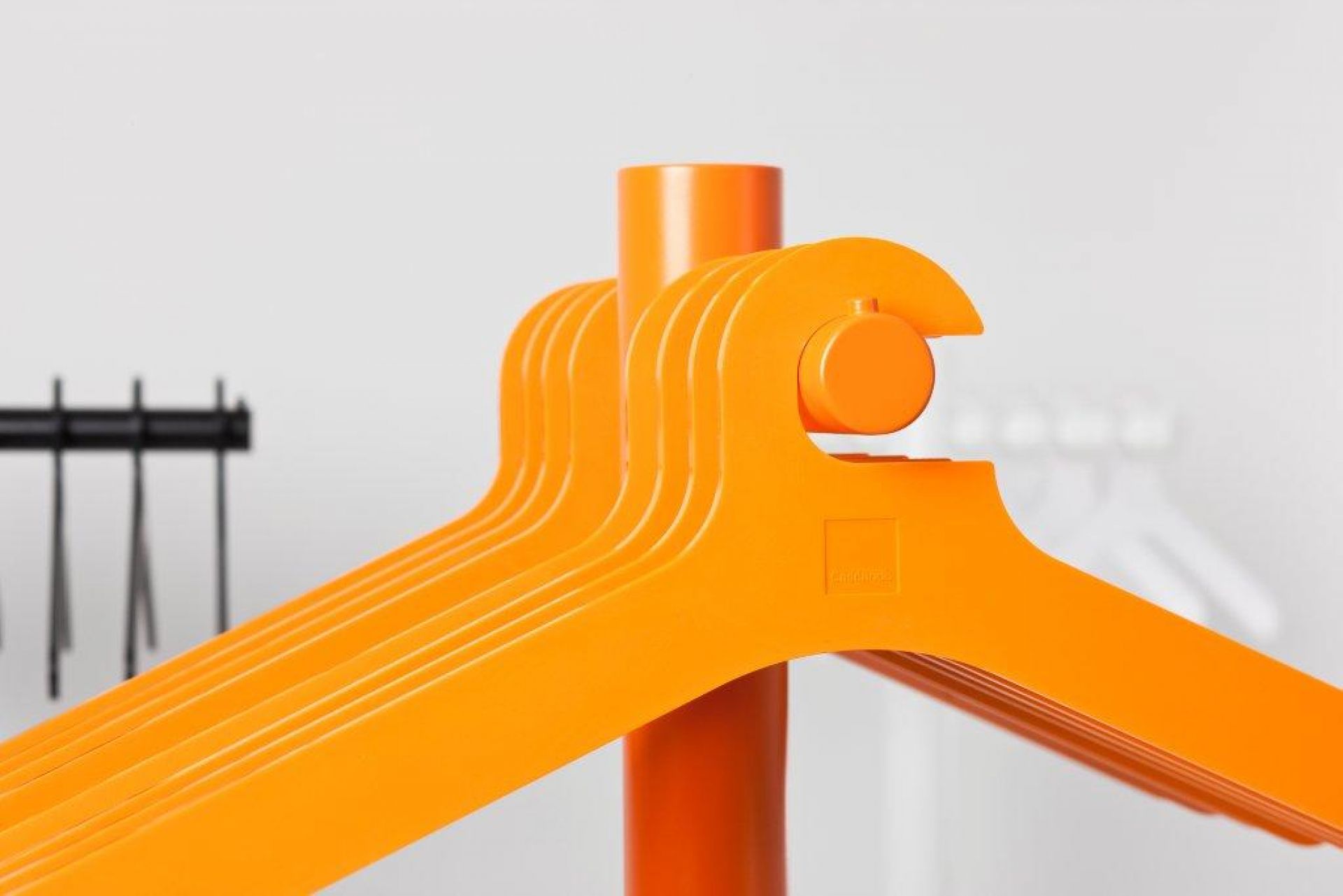 Orangefarbene Cascando Kleiderbügel am Ständer, moderne Garderobenlösung für Büro und Zuhause.