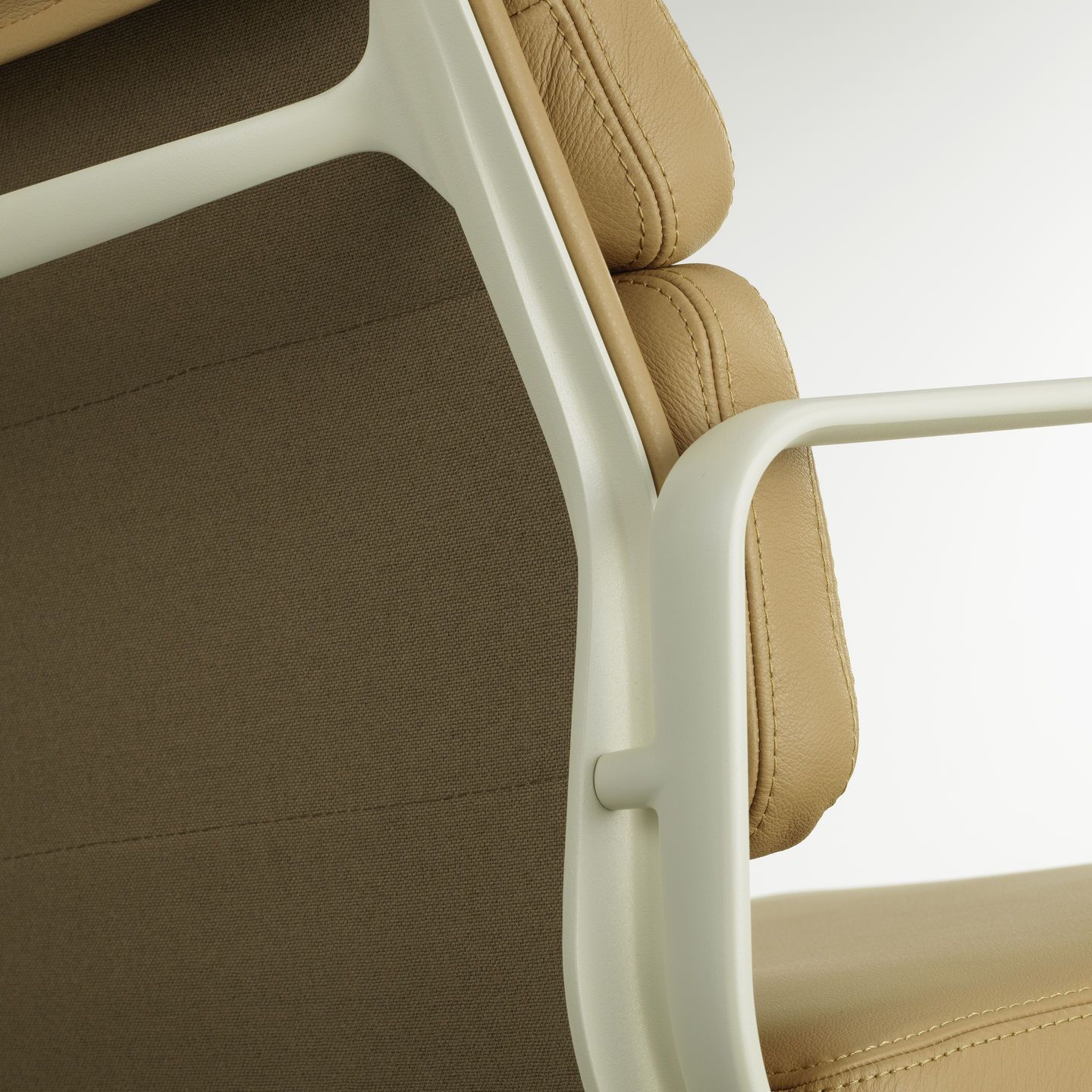 Detailaufnahme: Soft Pad Chair EA 231 von Vitra, helles Leder, brauner Stoff und weißes Gestell.