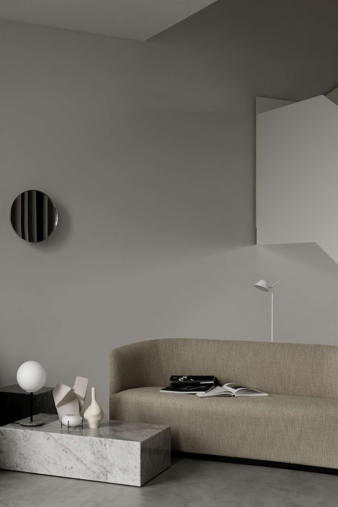 Audo Copenhagen Plinth Tisch aus Marmor im Wohnzimmer mit Sofa und Dekoration.