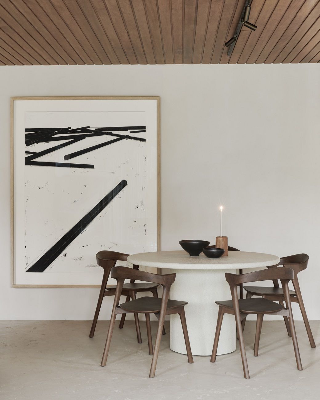 Elements Dining Table Esstisch Rund von Ethnicraft mit vier Holzstühlen in einem hellen Esszimmer.