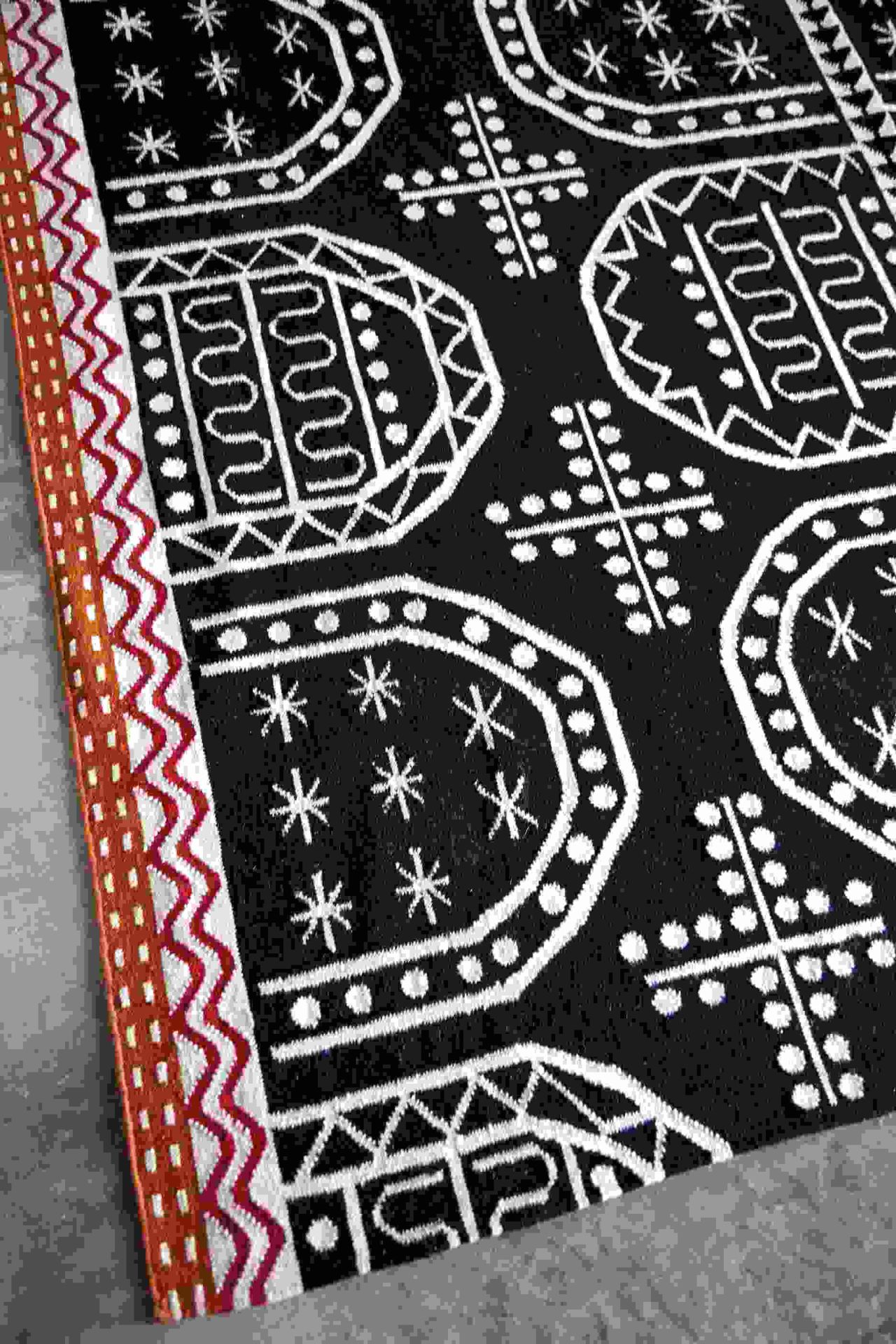 Detailaufnahme des Kilim Teppichs mit geometrischen Mustern in Schwarz und Weiß.