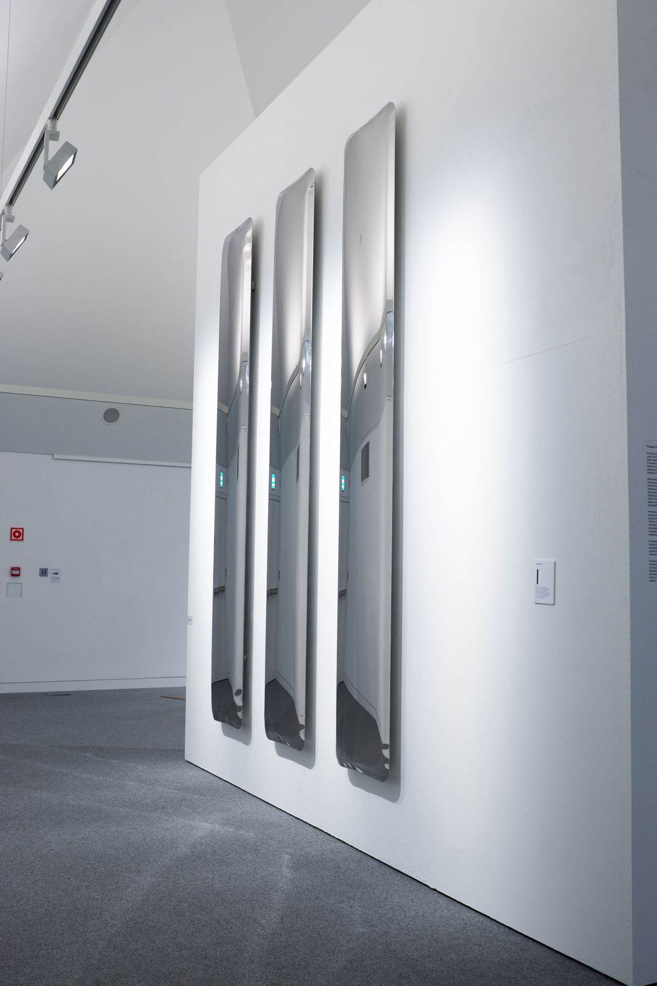 Drei Tafla Q Spiegel von Zieta in einem minimalistischen Raum, reflektierendes Designobjekt für moderne Innenarchitektur.