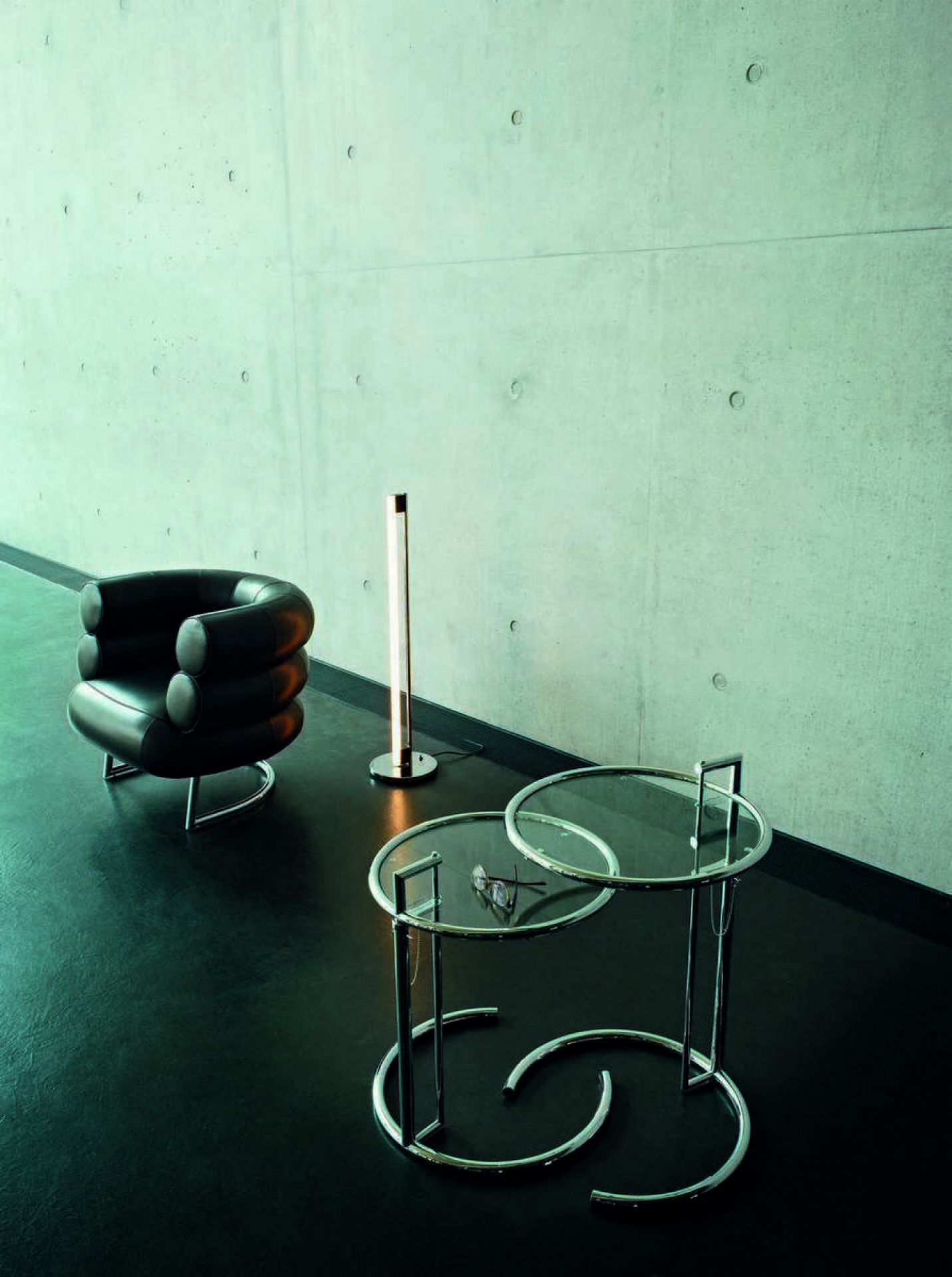 ClassiCon Tube Light Stehleuchte neben Sessel und Beistelltisch, modernes Wohnambiente mit Designermöbeln.