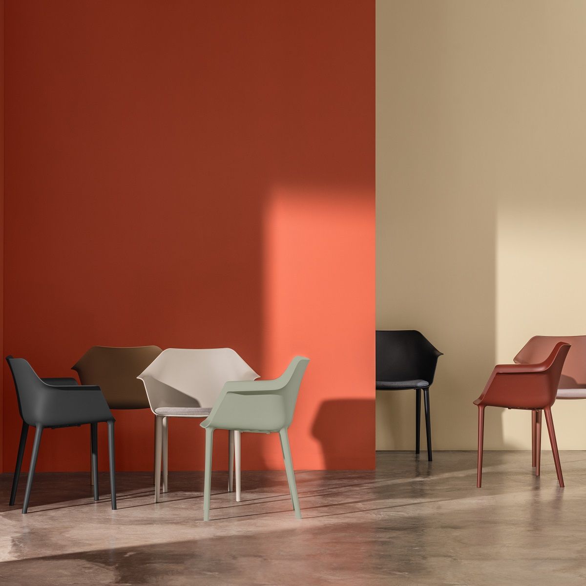 Gala Pure Eco Sessel von Andreu World in verschiedenen Farben vor farbigen Wänden.