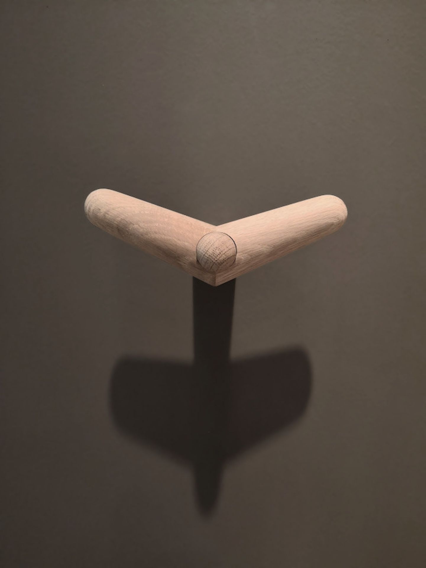 Detailaufnahme des Tail Wing Haken von Woud, ein moderner Wandhaken aus hellem Holz für Garderobe und Bad.