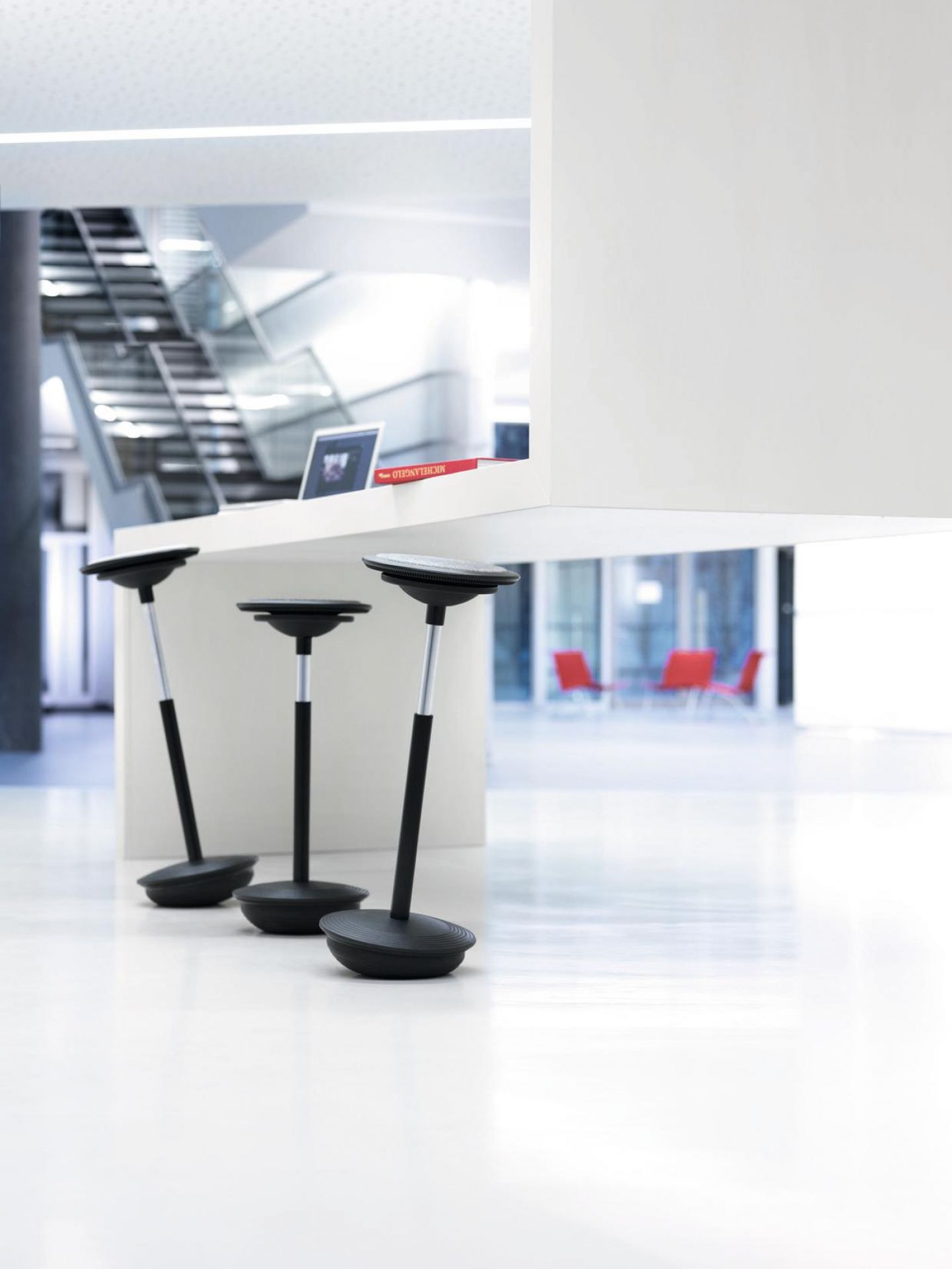 Drei schwarze Wilkhahn Stitz Stehhocker im modernen Büro, ergonomische Sitzmöbel für dynamisches Sitzen und Stehen.