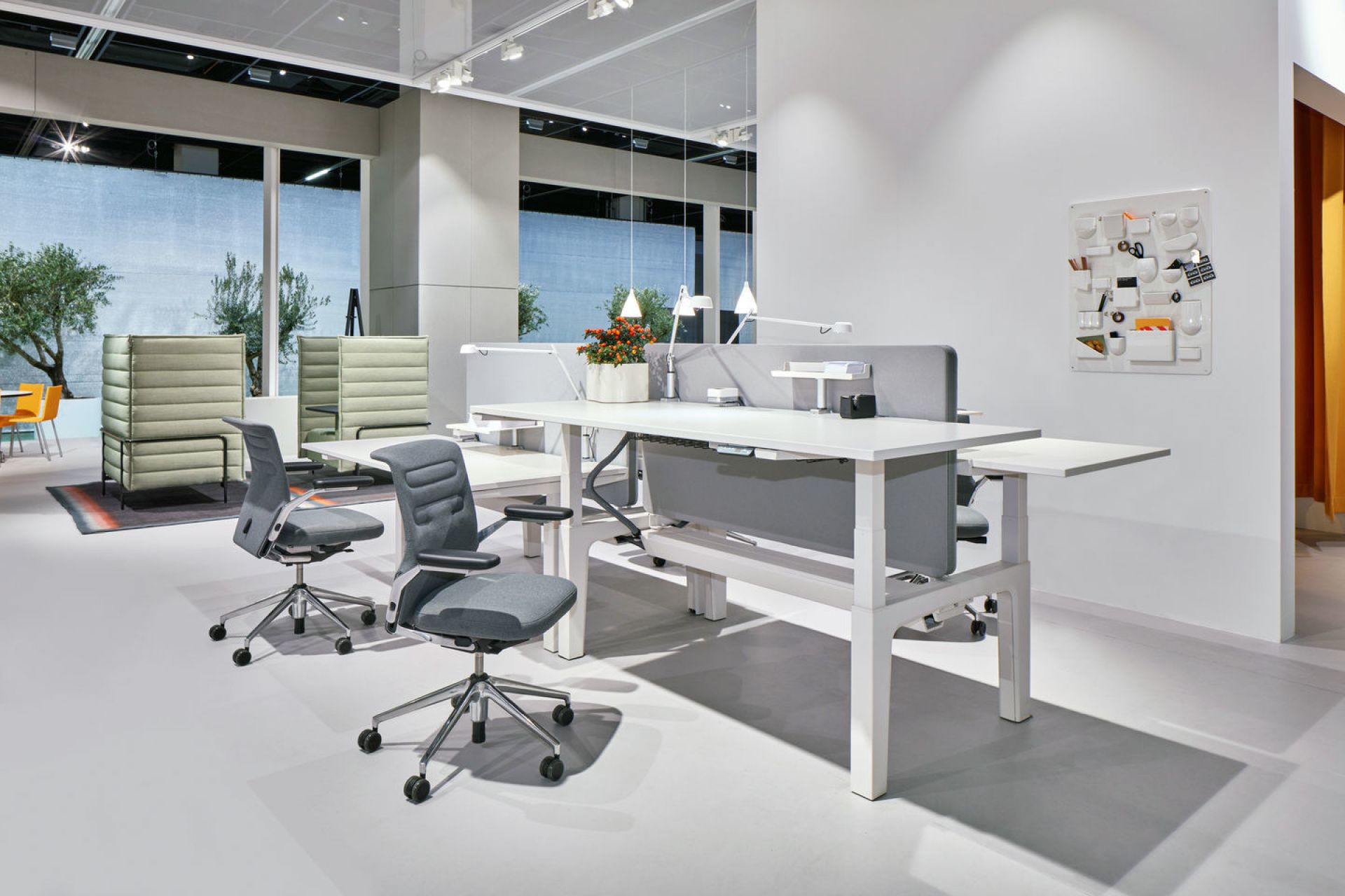 Grauer AC5 Bürodrehstuhl von Vitra mit verstellbarer Lumbalstütze im modernen Büro mit weißen Schreibtischen.