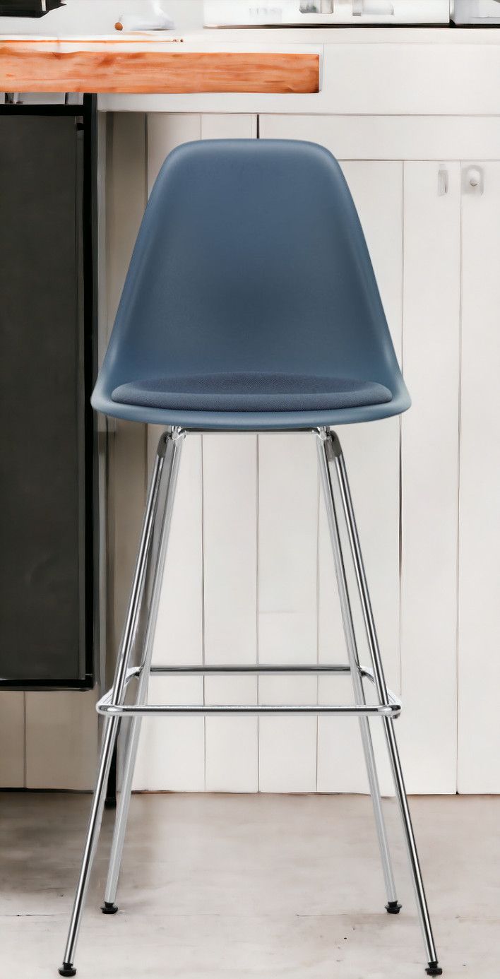 Blauer Eames Plastic Bar Stool Barhocker von Vitra mit Sitzpolster und Chromgestell.