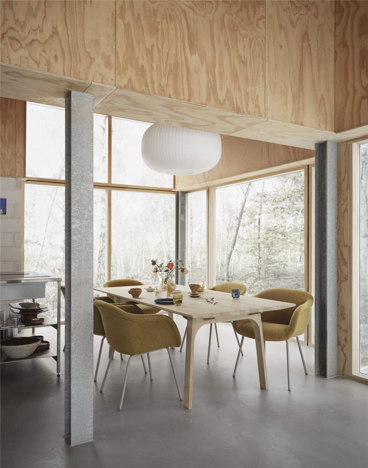 Muuto Earnest Esstisch ausziehbar mit Stühlen in hellem Raum mit großen Fenstern.
