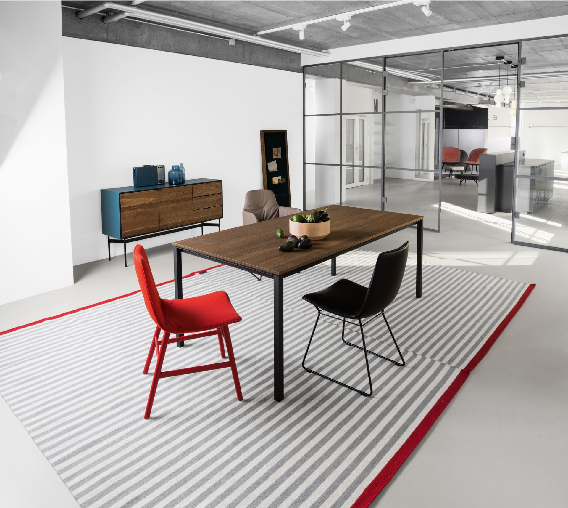 Janua S 600 Tisch Eiche geräuchert im modernen Esszimmer mit Stühlen und Teppich.