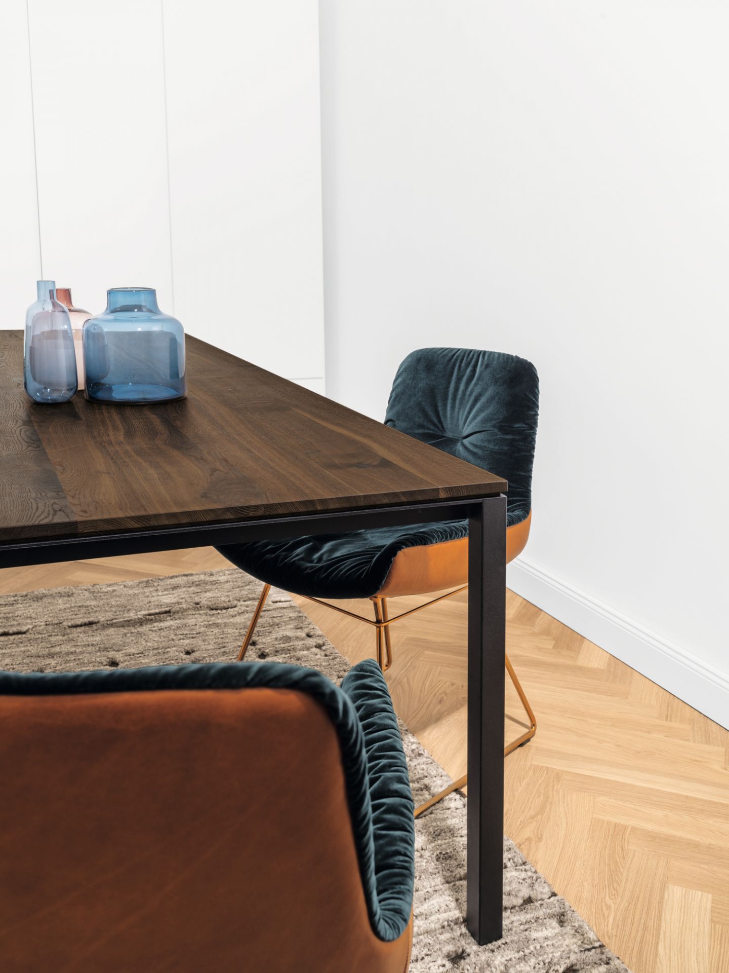 Janua S 600 Tisch Eiche geräuchert mit Stühlen und Vasen im modernen Esszimmer.