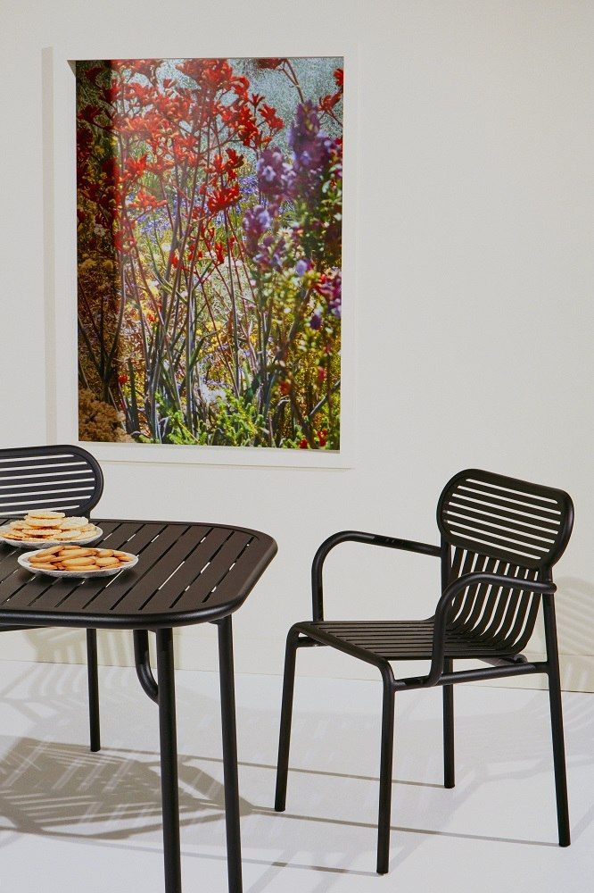 Week-End Garden chair Armlehnenstuhl von Petite Friture in Schwarz neben Gartentisch mit Keksen.