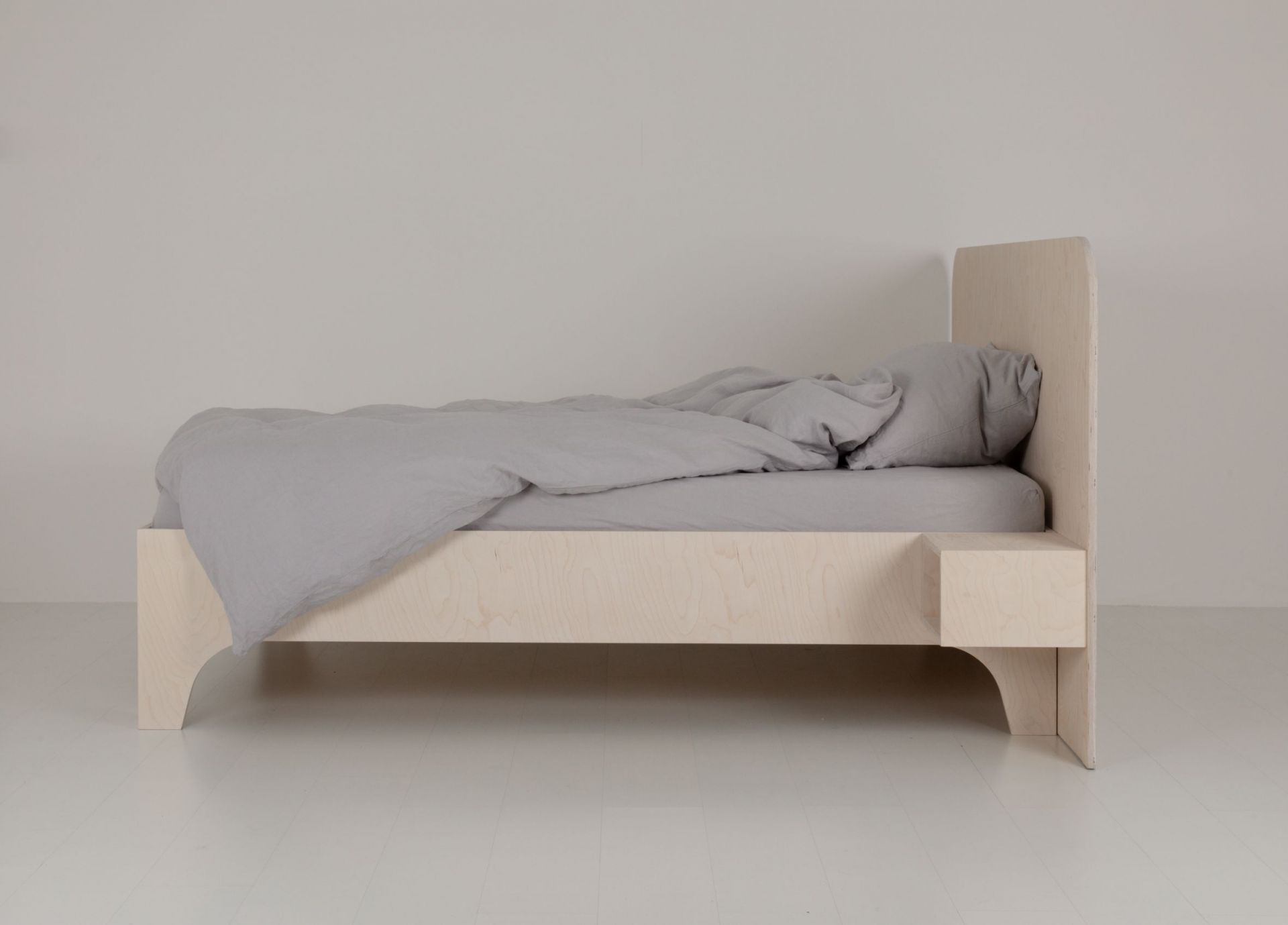 VALENTINA Bett 180x200 cm aus hellem Holz mit grauer Bettwäsche und Nachttischablage.