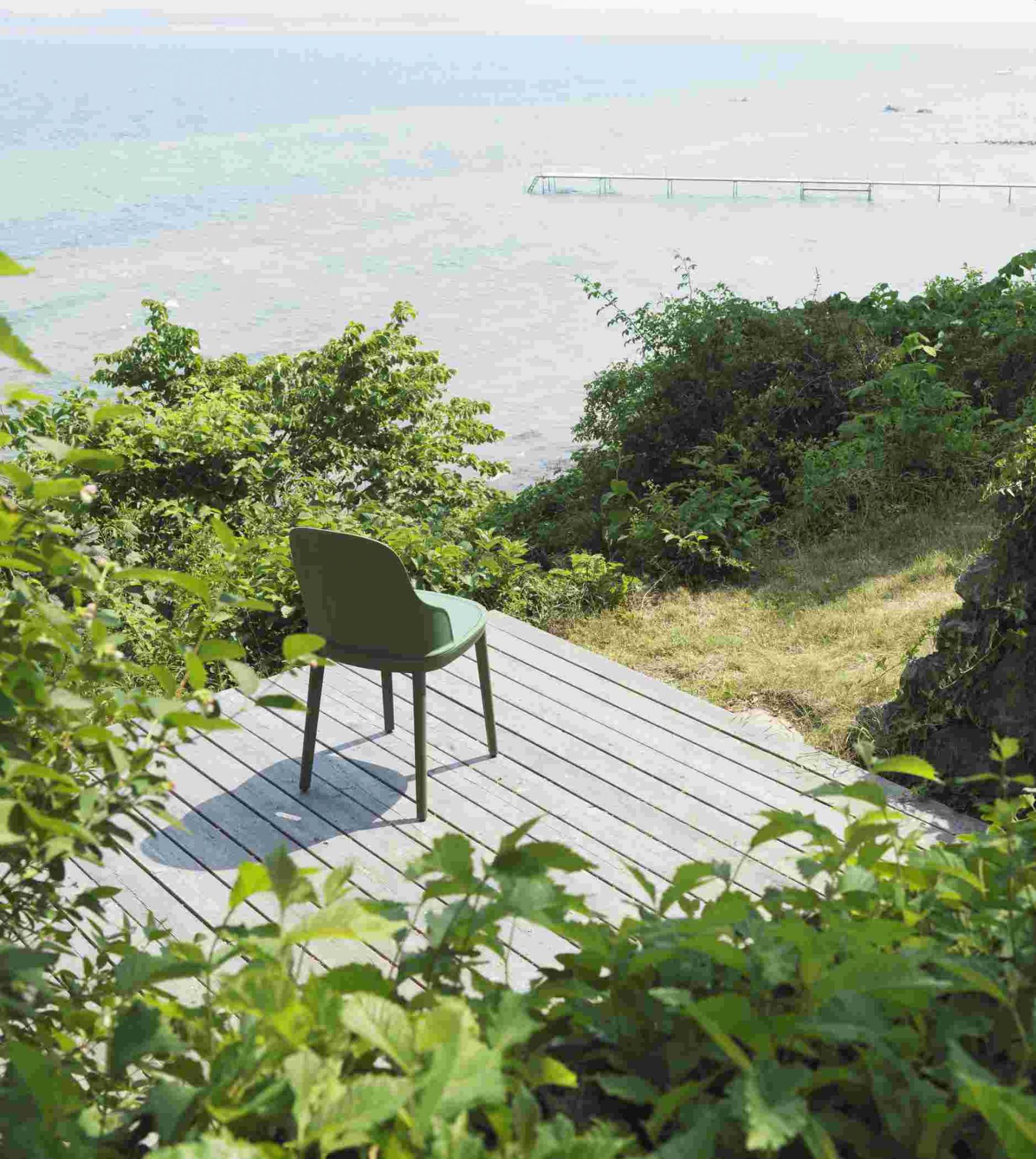 Allez Chair von Normann Copenhagen in Olivgrün auf Holzterrasse mit Meerblick, Gartenstuhl für den Außenbereich.