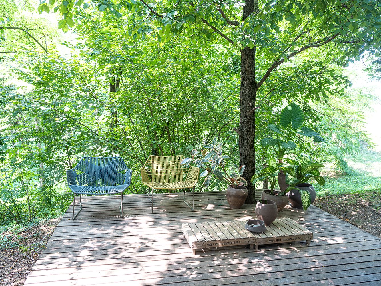 Tropicalia Lounge Sessel von Moroso im Outdoor-Bereich auf Holzterrasse mit grüner Umgebung.