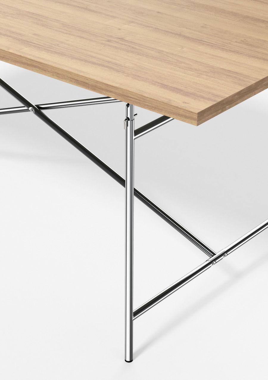 Detailansicht des Eiermann Tischgestells mit hellbrauner Tischplatte und verchromtem Stahlrohr-Design.