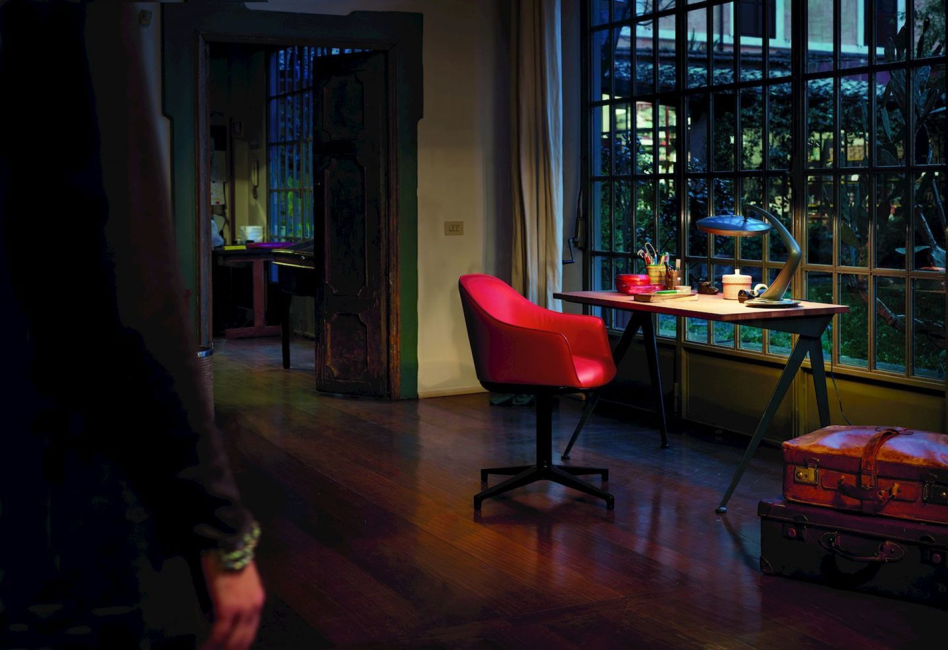 Roter Vitra Softshell Chair mit Viersternfuß vor Schreibtisch und Fenster, Bürostuhl für modernes Wohnambiente.