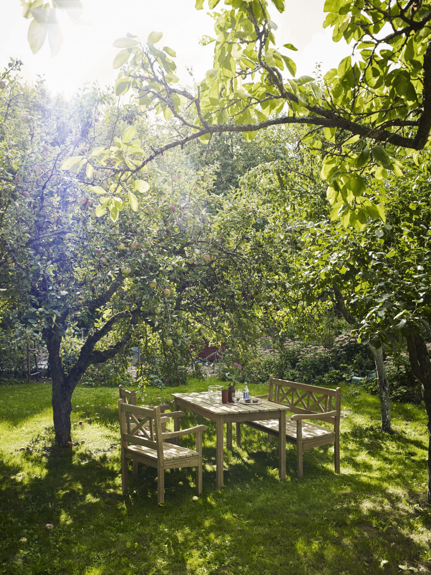 Skagen Gartenmöbel Set von Skagerak by Fritz Hansen unter einem schattigen Baum auf einer Wiese.