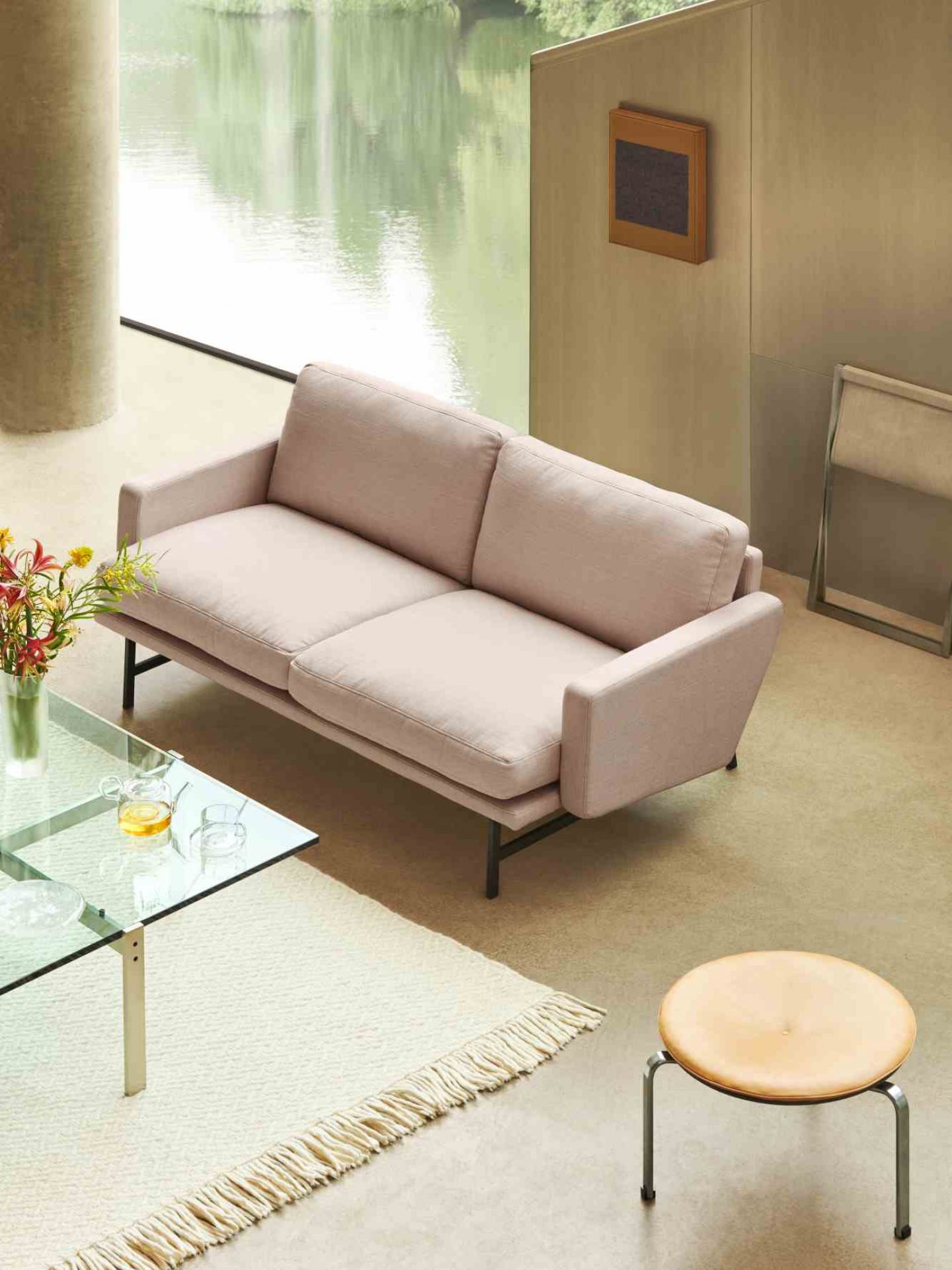 Beiges Lissoni Sofa von Fritz Hansen im modernen Wohnzimmer mit Glascouchtisch und Hocker.