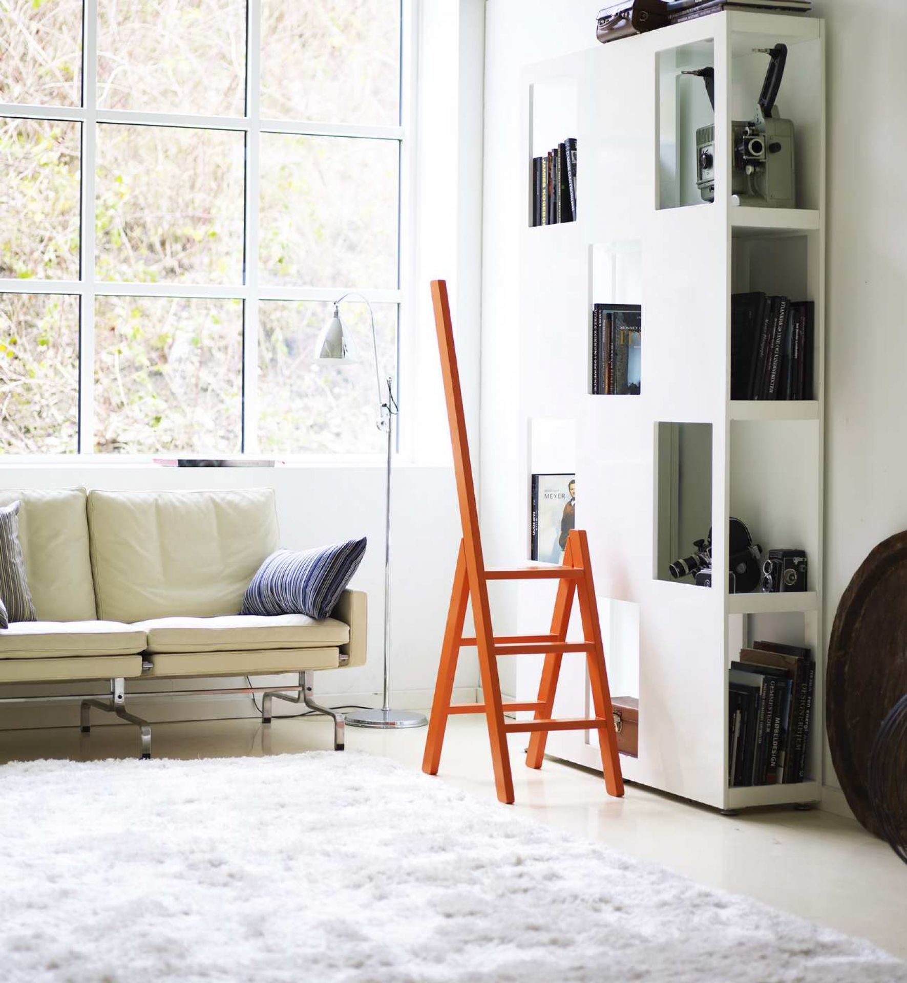 Orangefarbene Hindevadgaard Trittleiter aus Holz im modernen Wohnzimmer, ideal als Steighilfe und Dekoration.