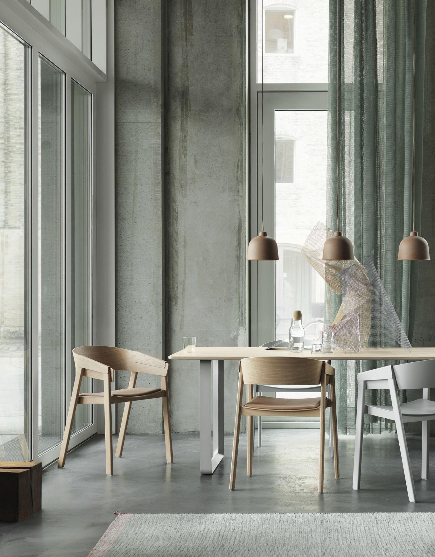 Esszimmer mit Muuto Grain Pendelleuchten in Braun über einem Holztisch.