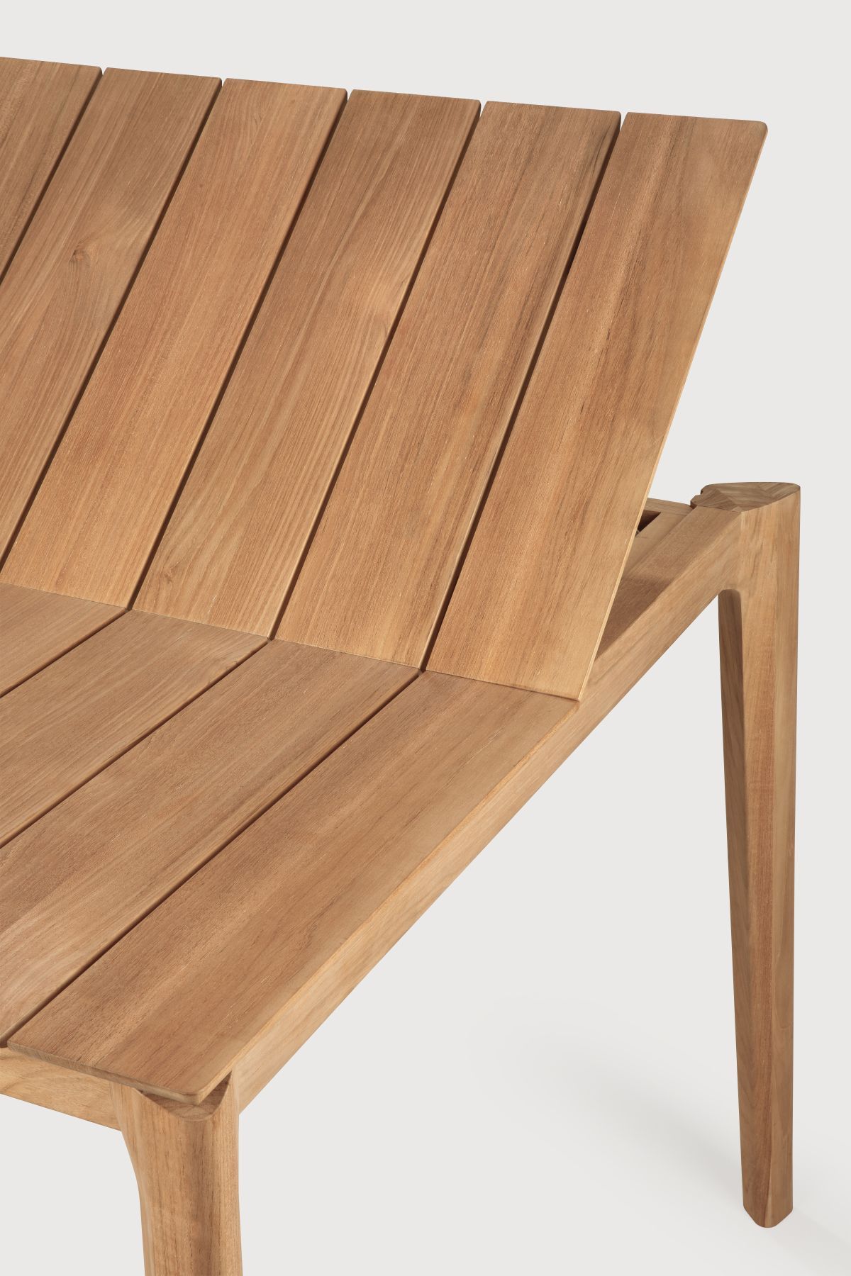 Detailaufnahme des Ethnicraft Bok Outdoor Tisches: Teakholz-Tischplatte mit Lamellen und Tischbein.