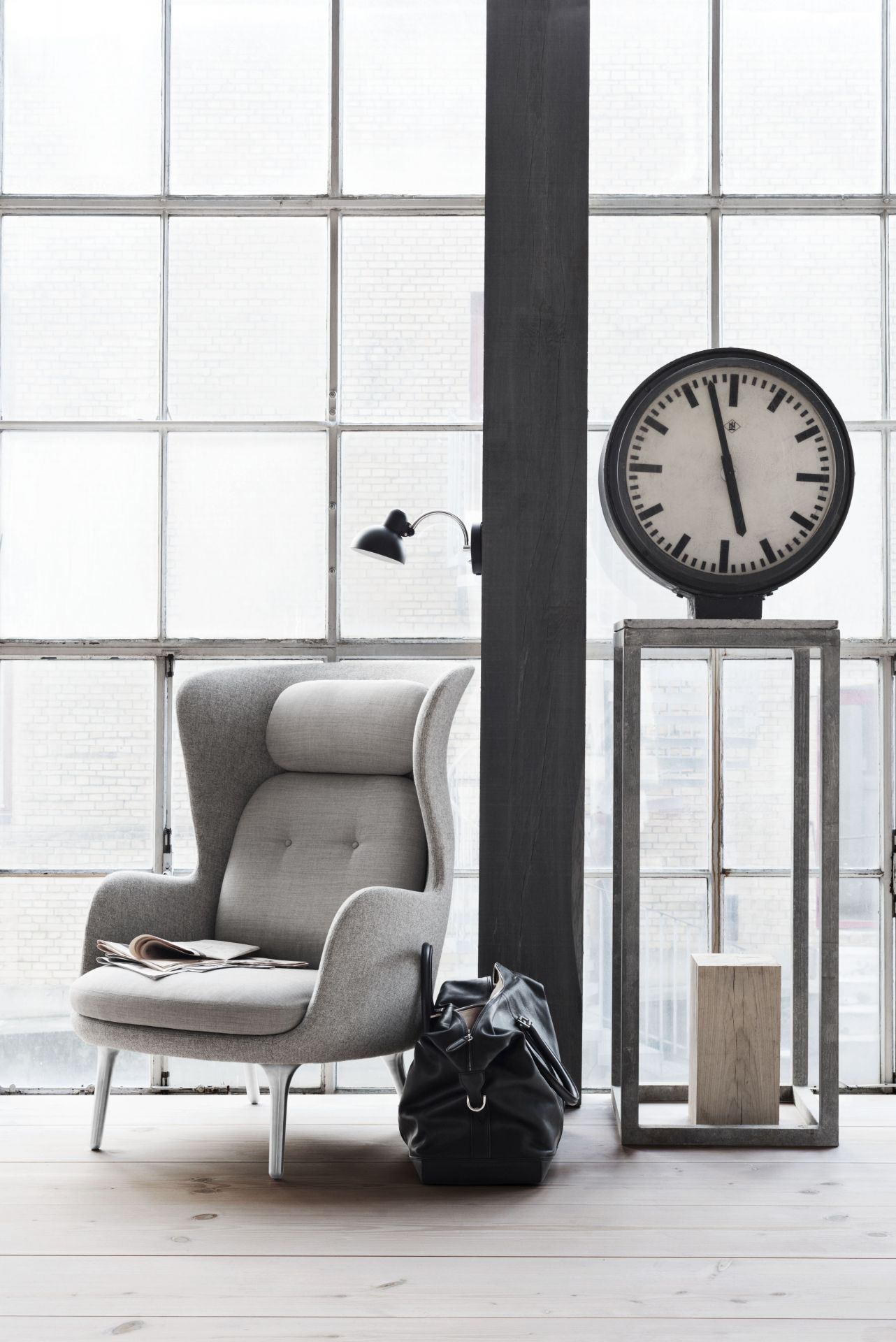 Grauer Ro Sessel von Fritz Hansen mit hoher Rückenlehne und Kopfstütze vor Fenster. Design Möbel.