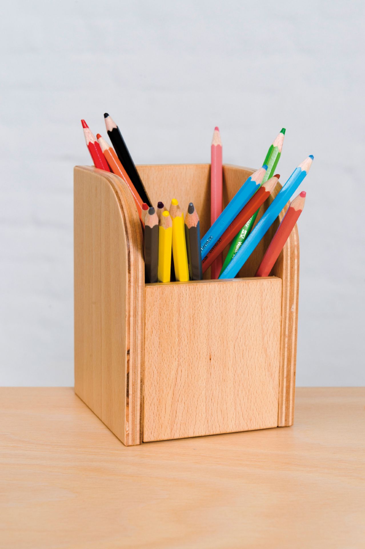 Growing Table Stiftehalter aus Buche, Teil des 9-teiligen Sets, gefüllt mit bunten Stiften.