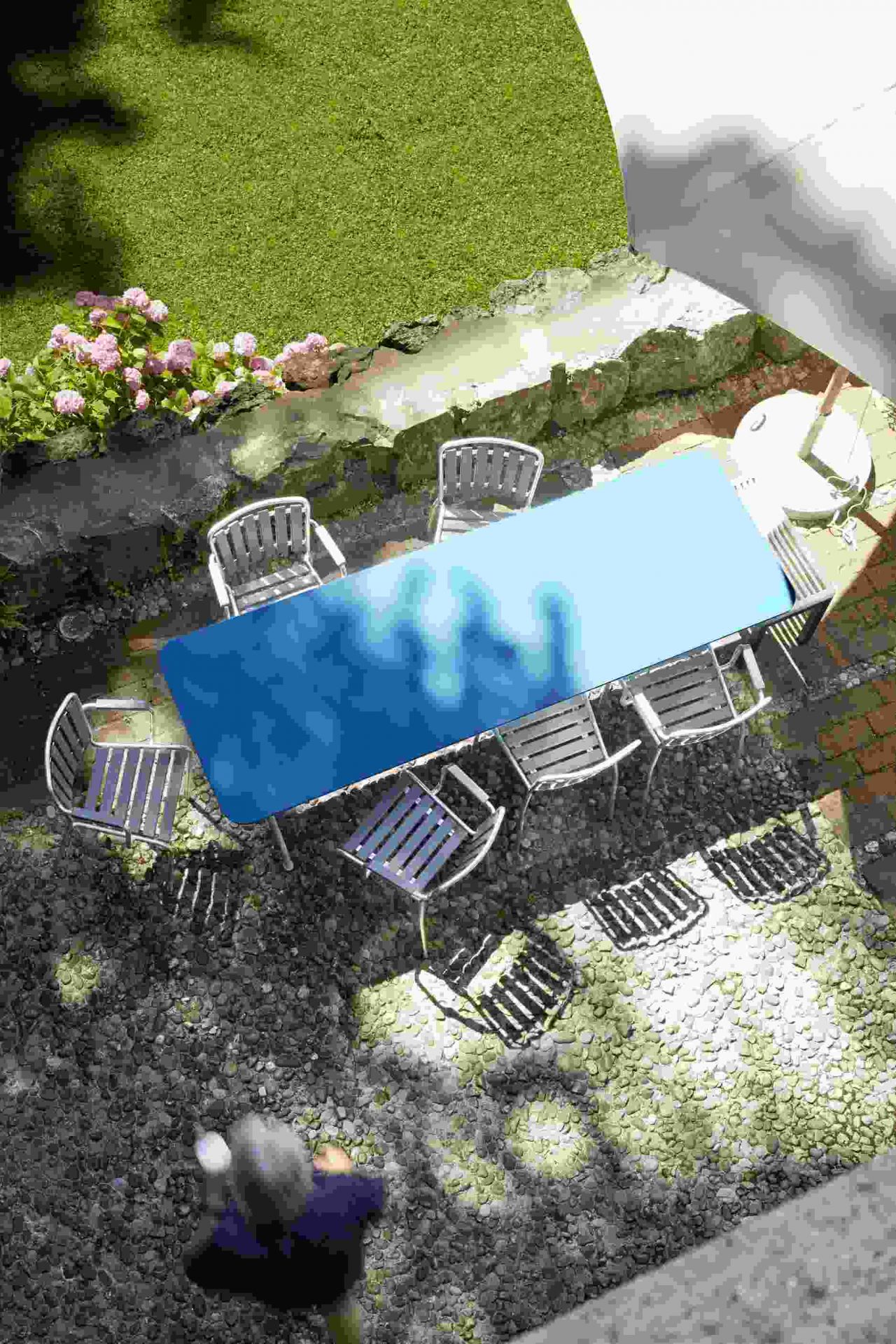 Aschgrauer Haefeli Sessel von Embru im Outdoor-Bereich mit Tisch und weiteren Gartenmöbeln.