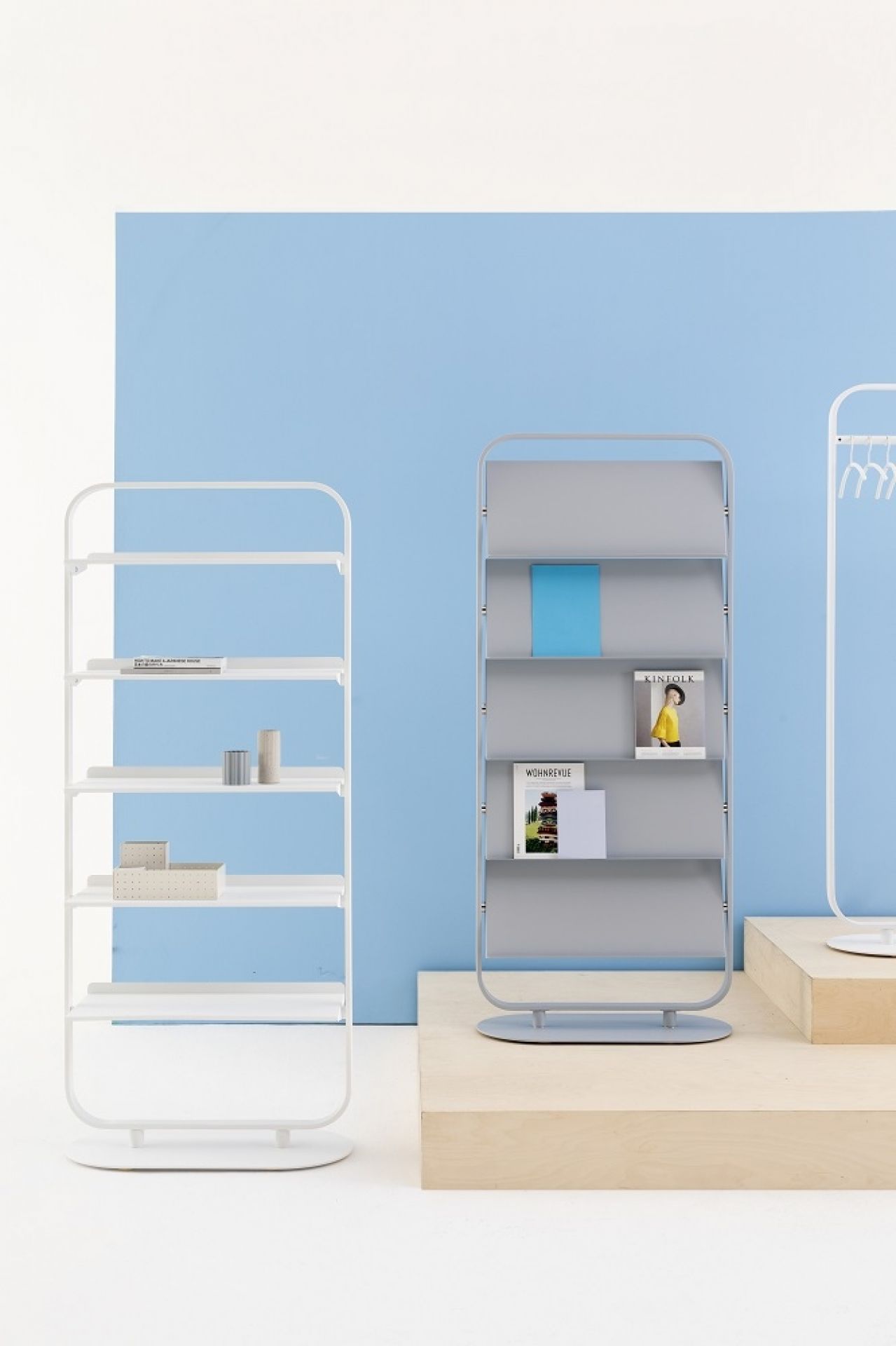 Focus Prospekthalter von Cascando: Graue Prospektablage mit Zeitschriften und blauer Broschüre, minimalistisches Design.