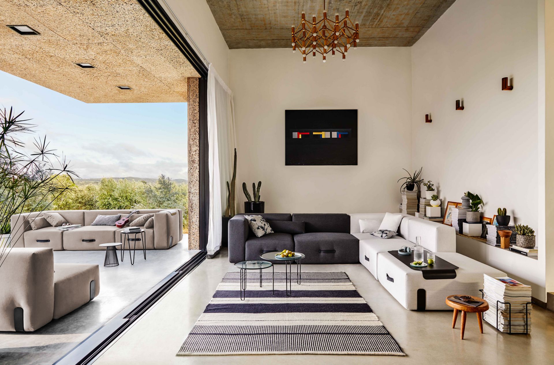 Helles Wohnzimmer mit Conmoto Miami Outdoor Sofa in Taupe und Blick ins Grüne.