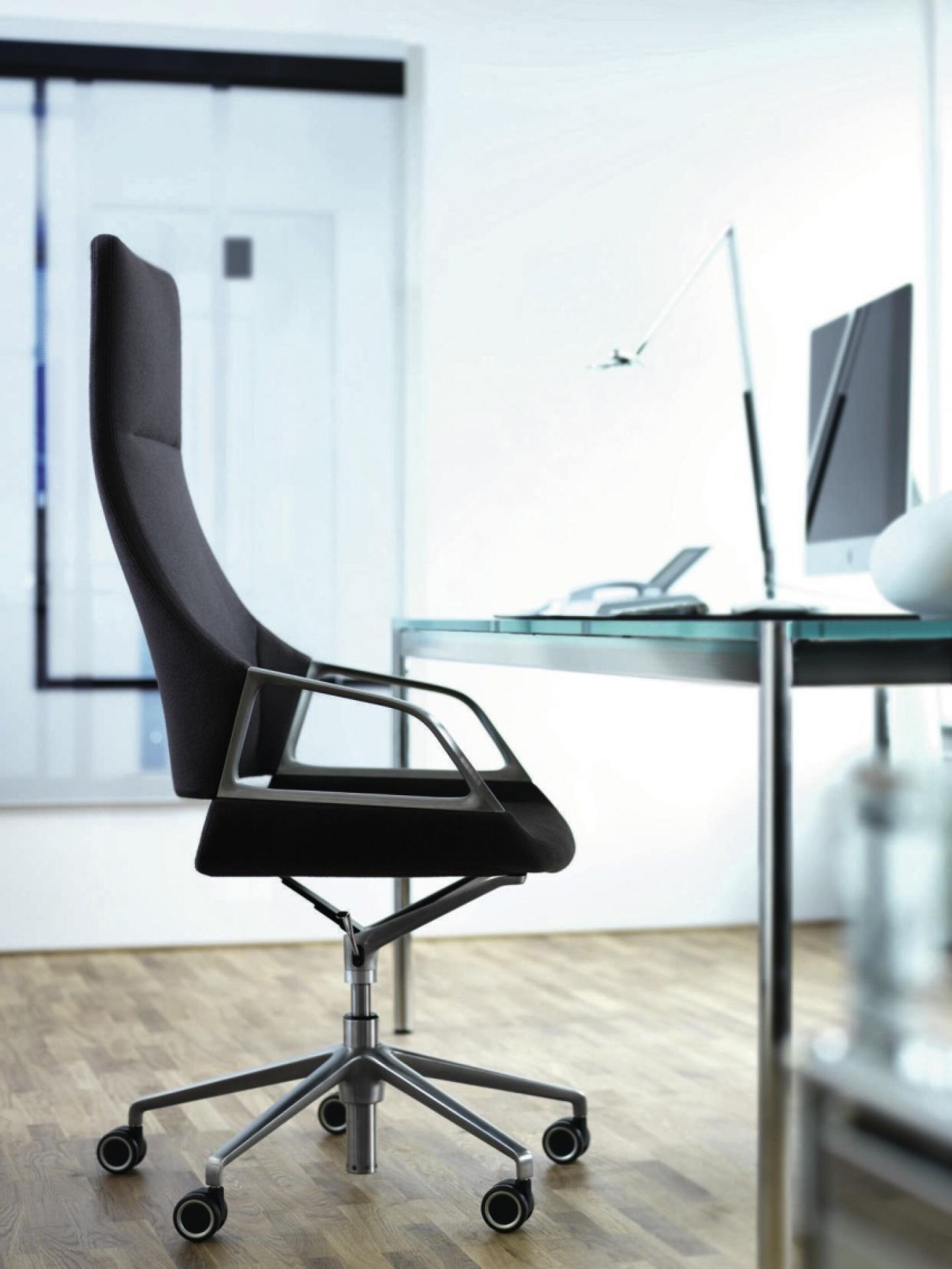 Wilkhahn Graph Drehsessel mit hoher Rückenlehne in Schwarz vor modernem Schreibtisch im Büro.