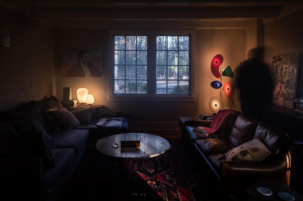 Gemütliches Wohnzimmer mit Design Stehlampe, Sofa, Teppich und Tischlampen für stimmungsvolle Beleuchtung.