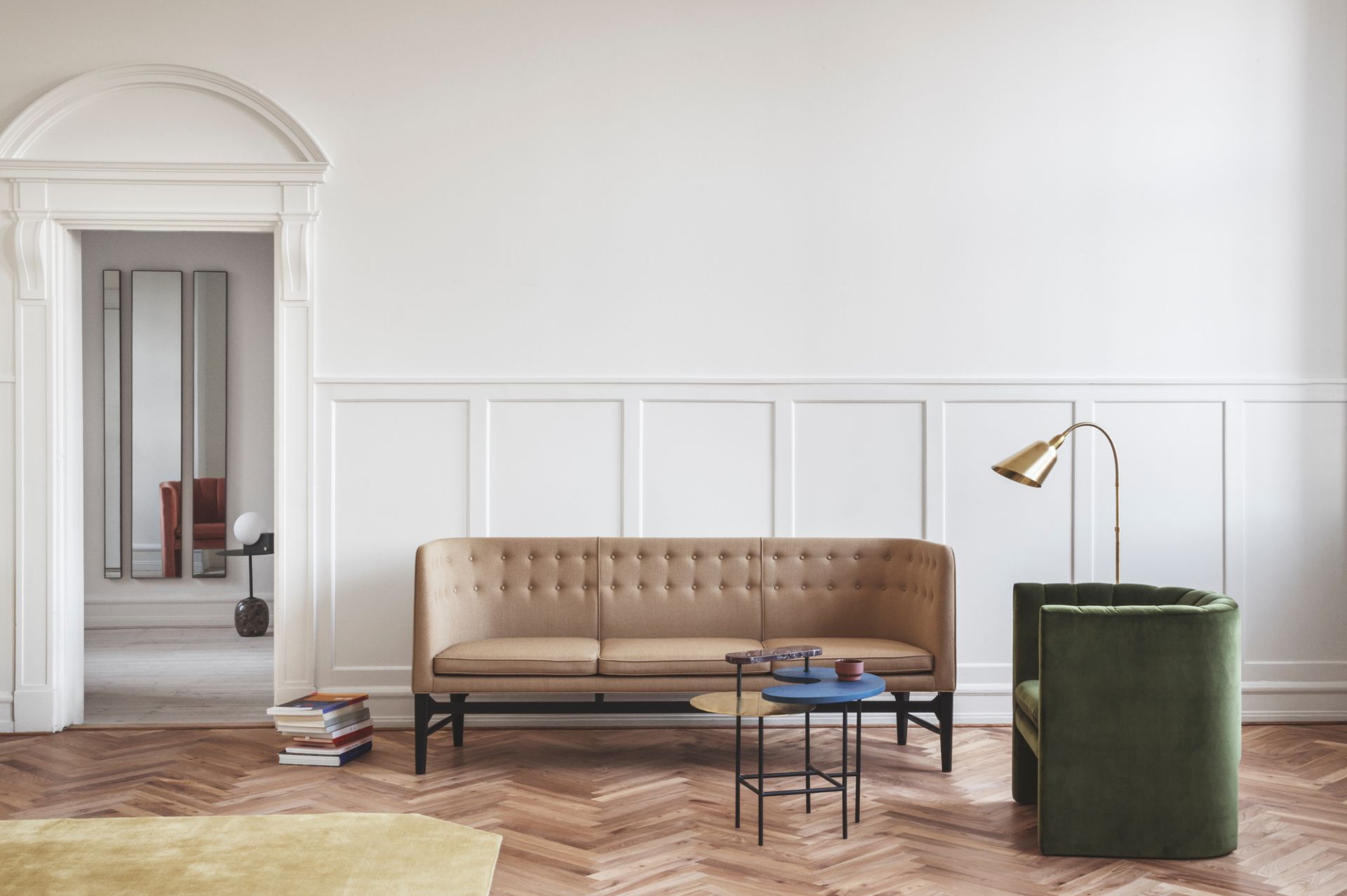 AndTradition Mayor Sofa, ein beiges 3-Sitzer Sofa mit Knopfleiste im modernen Wohnzimmer mit Parkettboden.