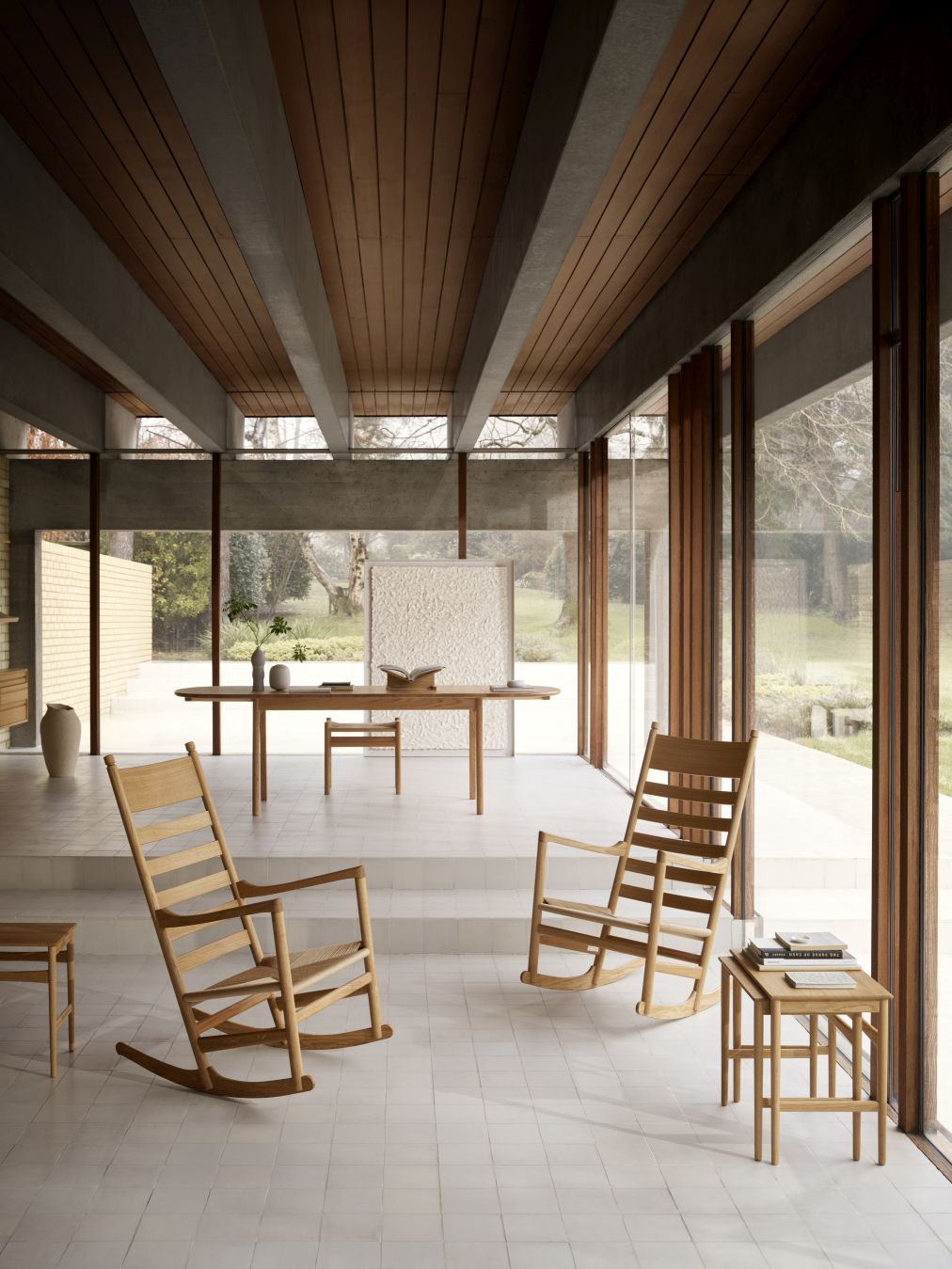Helle Innenaufnahme mit zwei CH45 Schaukelstühlen von Carl Hansen, Tisch und Stuhl im Hintergrund.